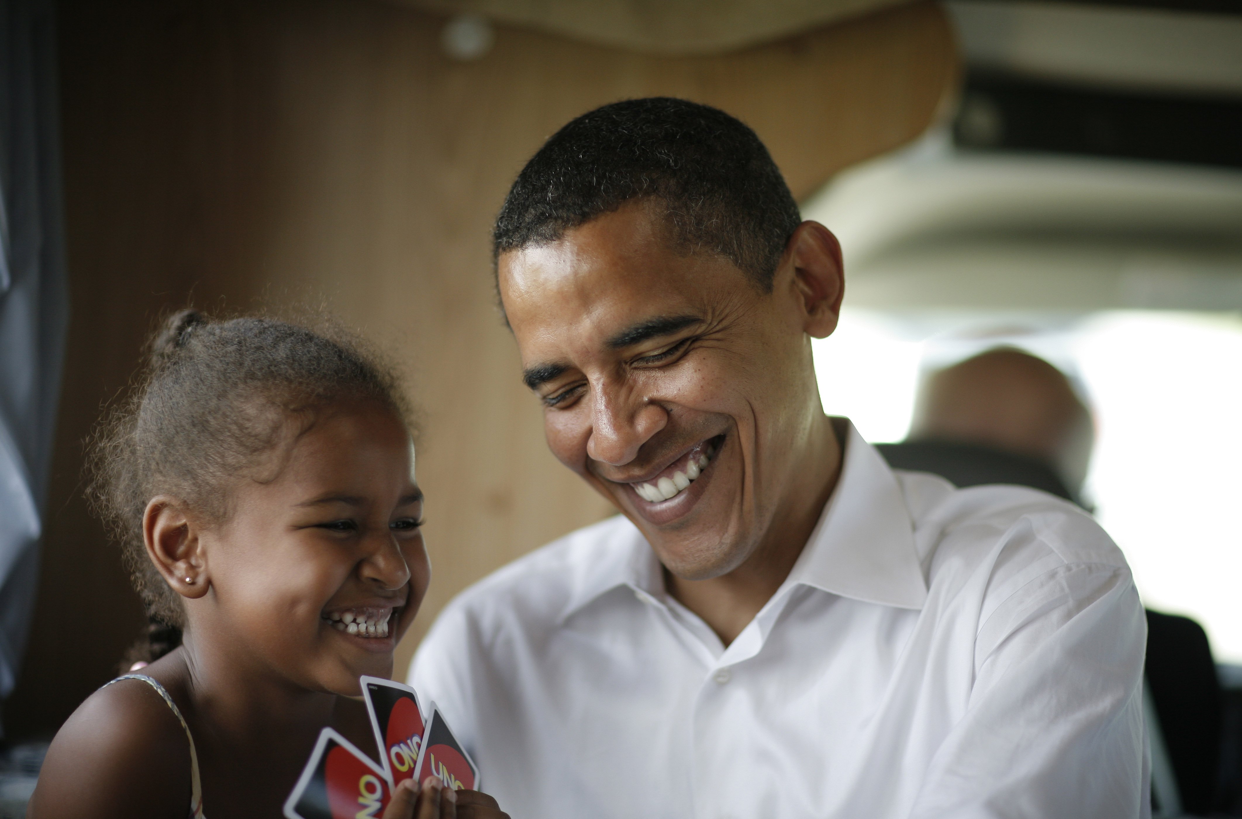 Sasha et Barack Obama jouent aux cartes dans leur camping-car lors d'une tournée de campagne entre Oskaloosa et Pella, dans l'Iowa, le 4 juillet 2007. | Source : Getty Images