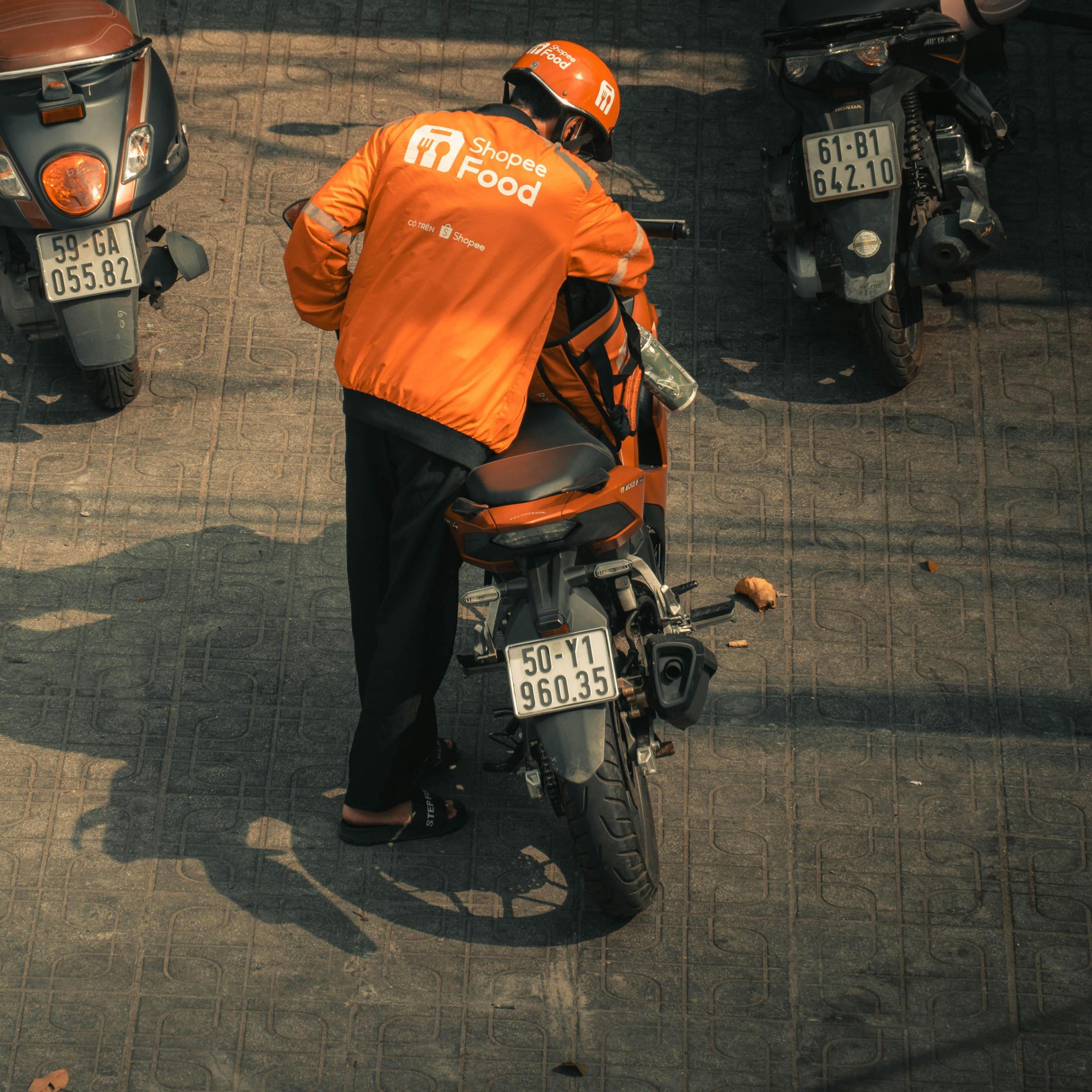 Un livreur de nourriture se met en selle sur sa moto | Source : Pexels