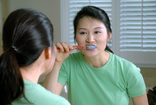 Une jeune femme se brossant les dents. l Source : Unsplash