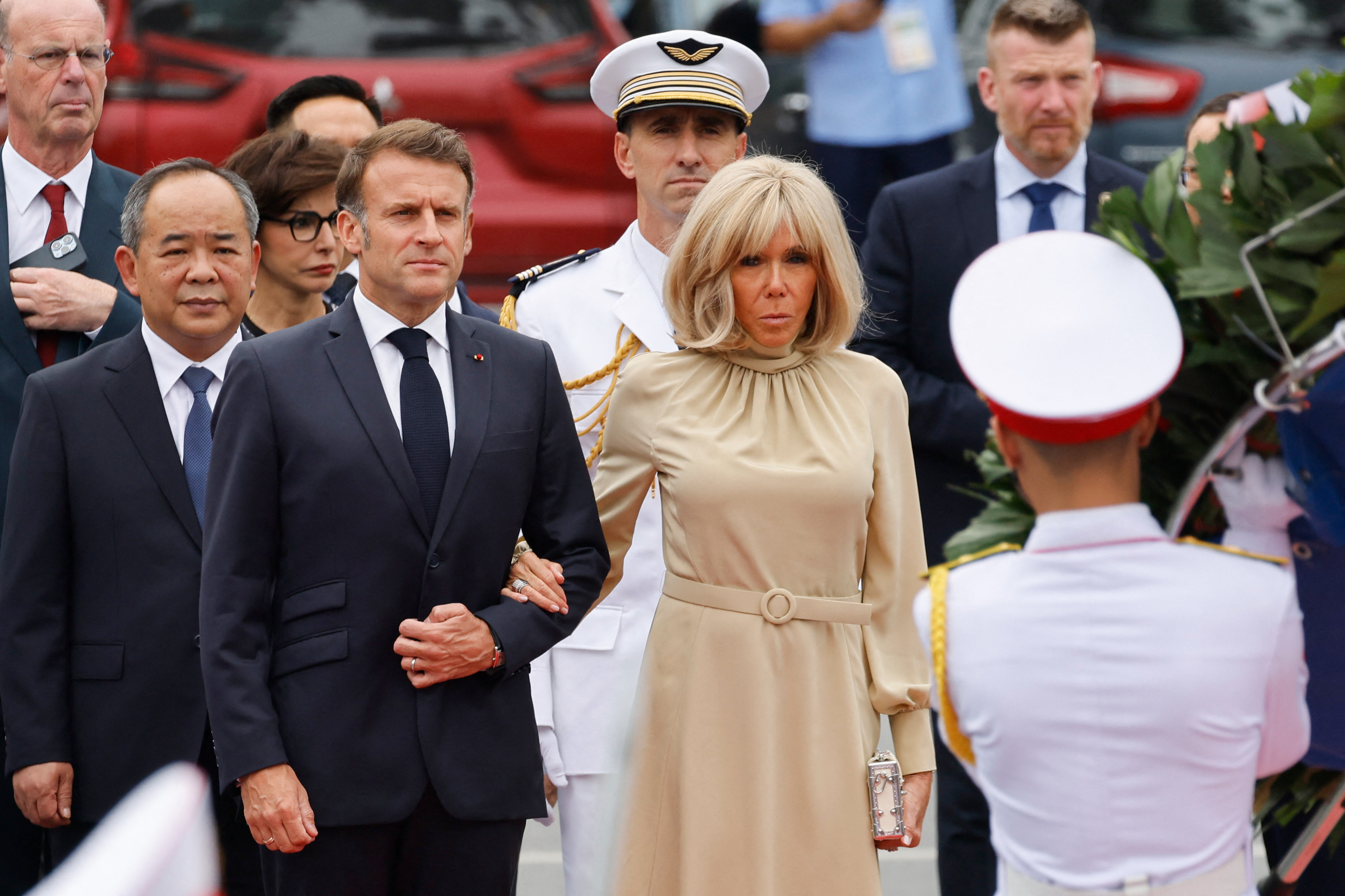 Le président français Emmanuel Macron (au centre, à gauche) et son épouse Brigitte Macron (au centre, à droite) participent à une cérémonie de dépôt de la gerbe au monument des héros et martyrs nationaux à Hanoï, le 26 mai 2025 I Source : Getty Images