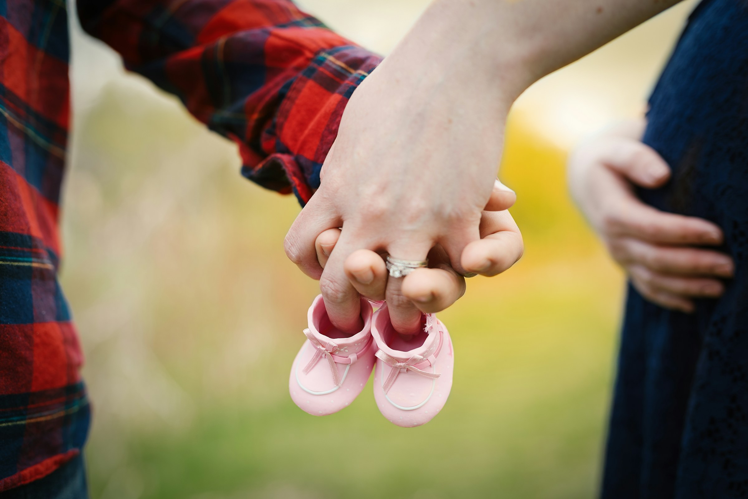 Un futur couple tenant une paire de minuscules chaussures roses | Source : Unsplash