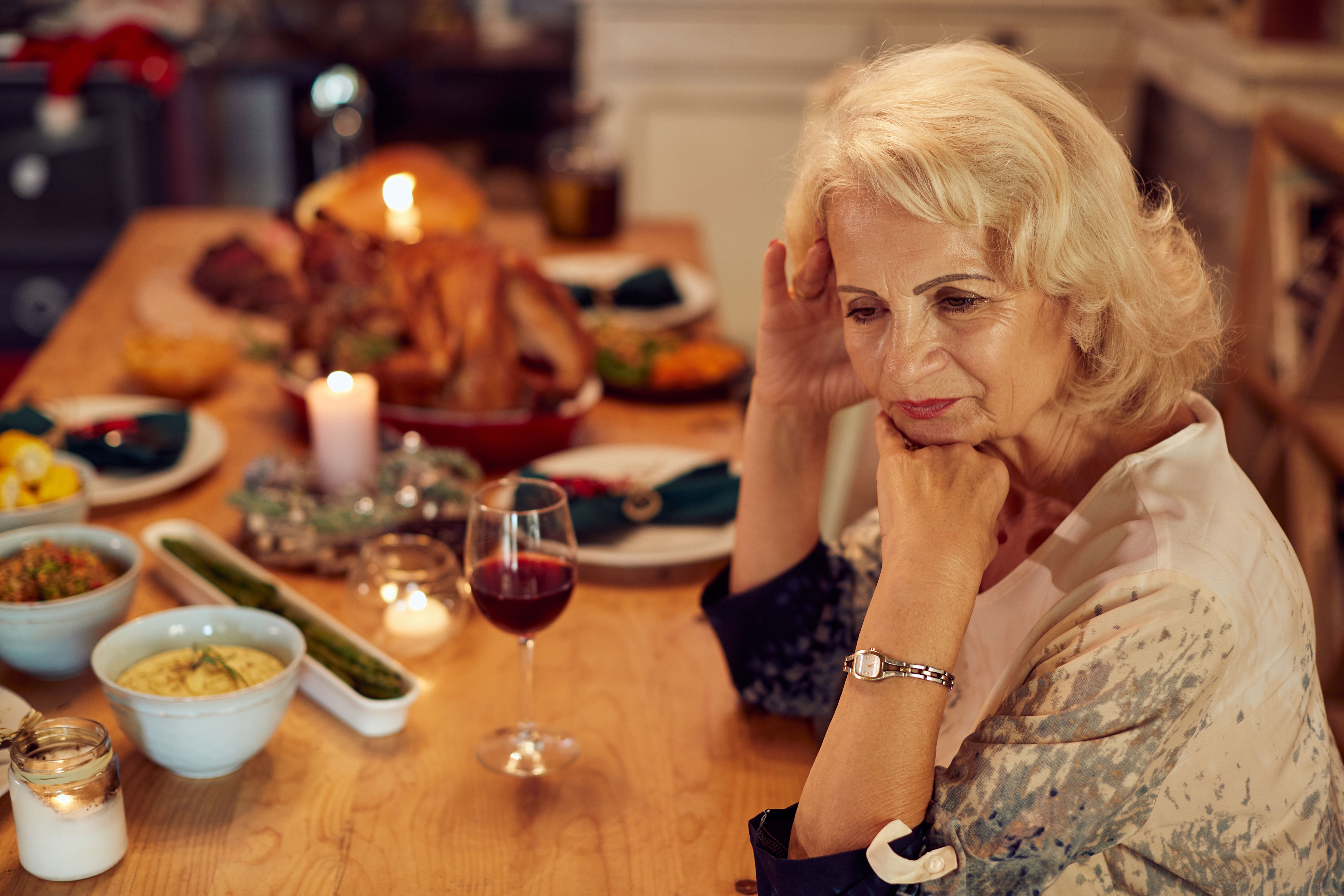 Une femme âgée bouleversée à une table de dîner. | Source : Getty Images