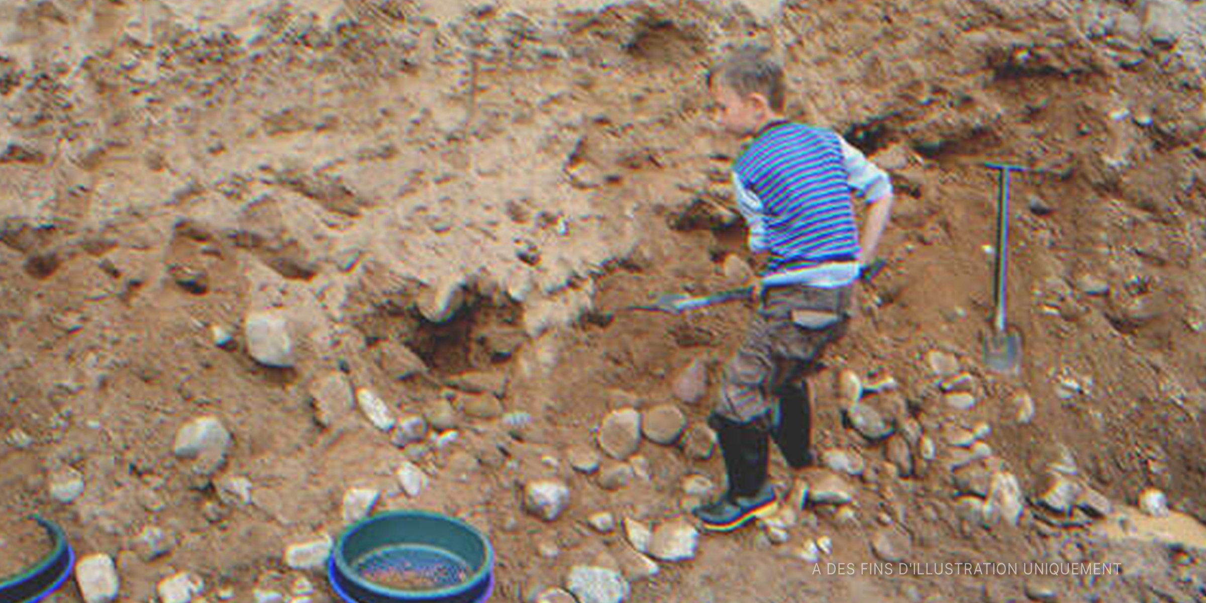 Un petit garçon qui creuse le sable. | Source : Shutterstock