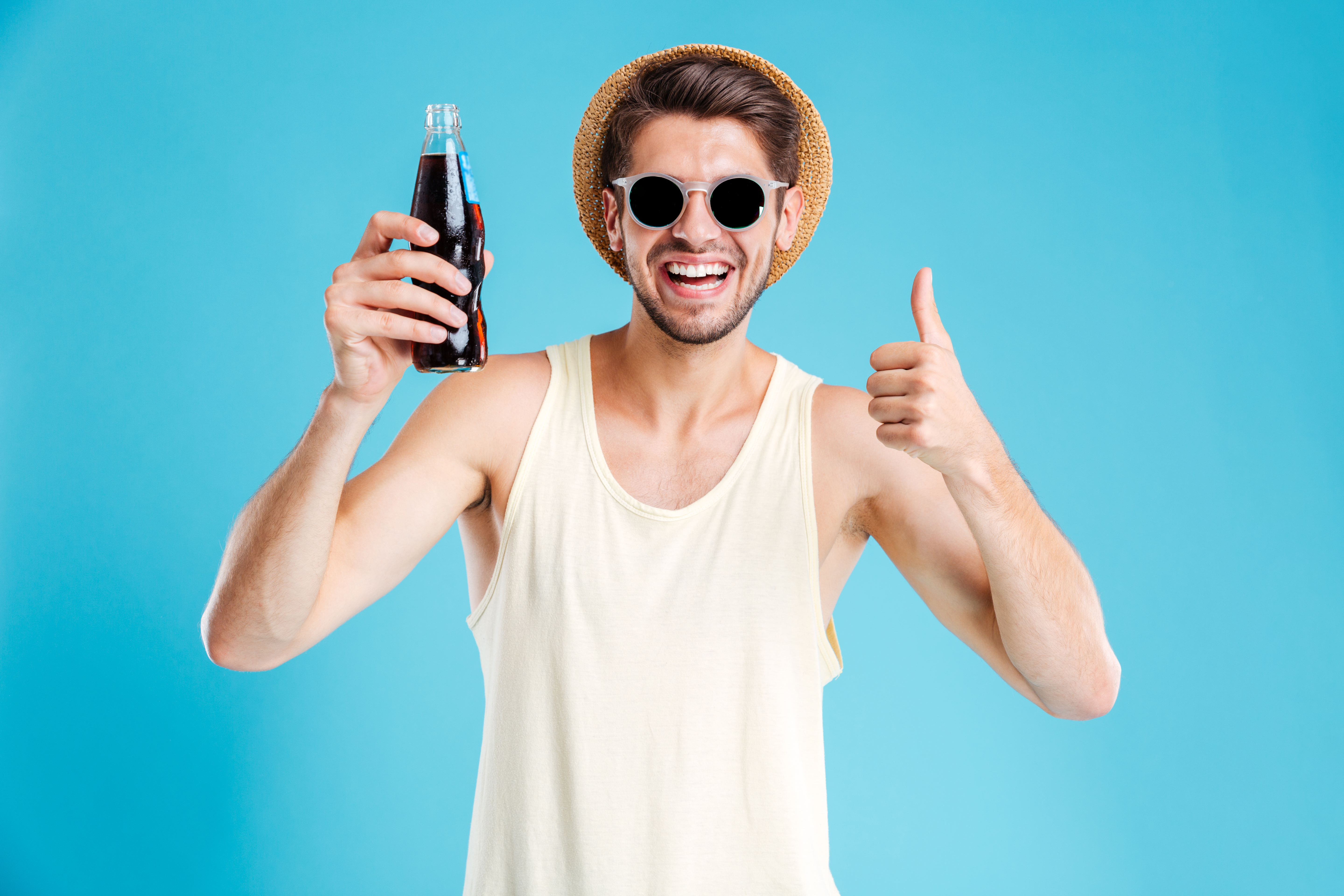 Un jeune homme heureux tenant un soda | Source : Shutterstock