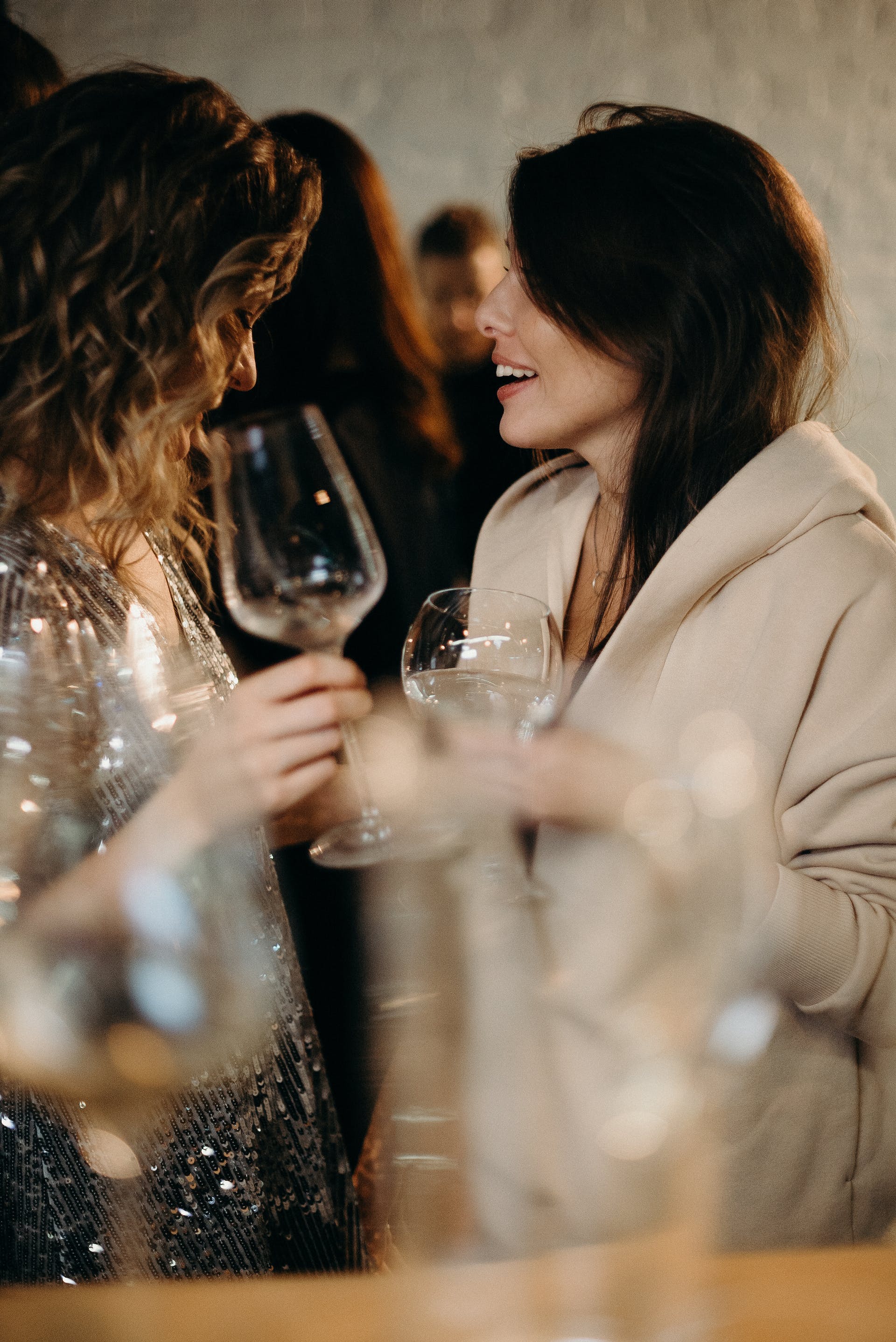 Mujeres hablando mientras sostienen unas copas | Fuente: Pexels