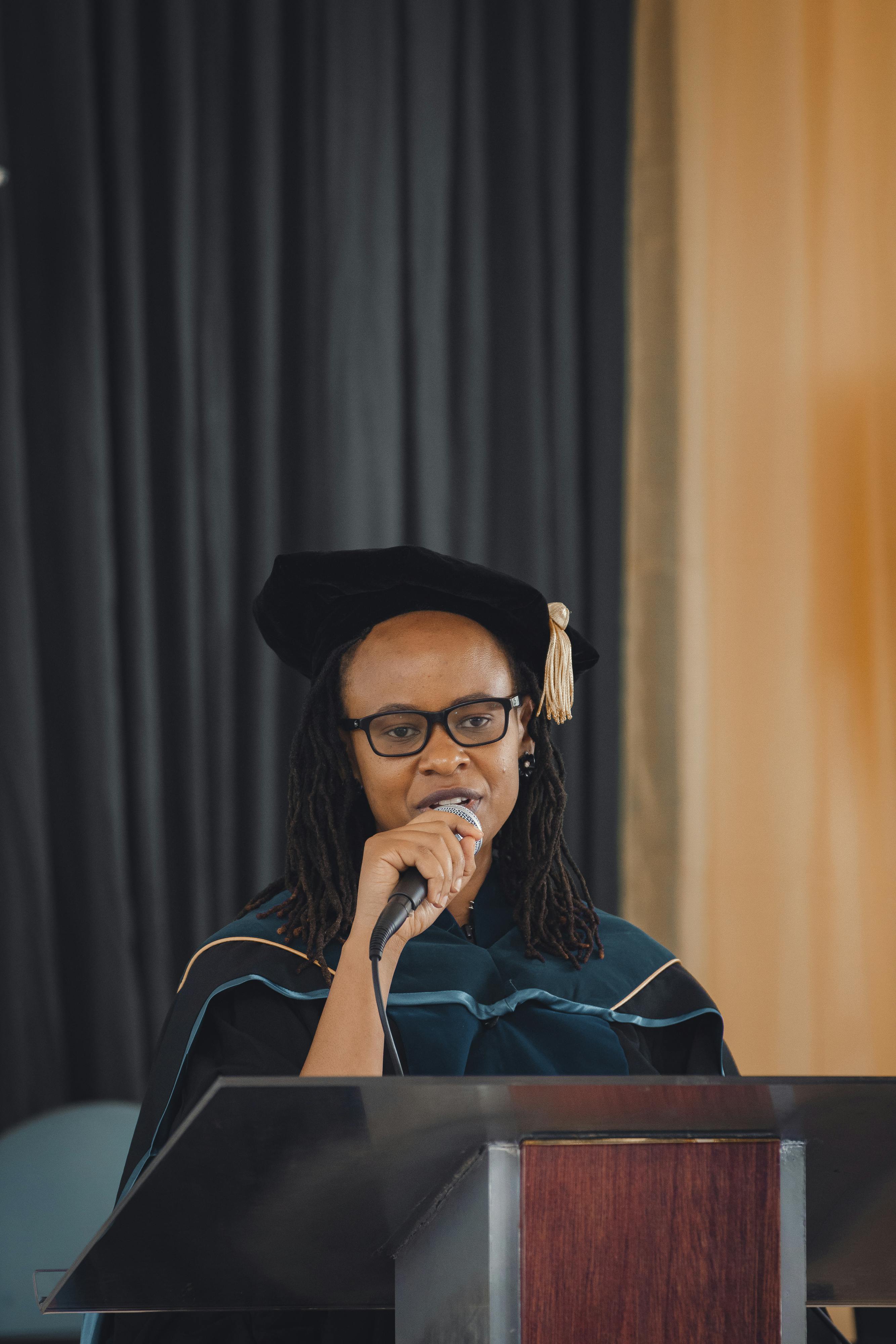 Un diplômé de l'enseignement supérieur s'exprimant au micro sur scène | Source : Pexels