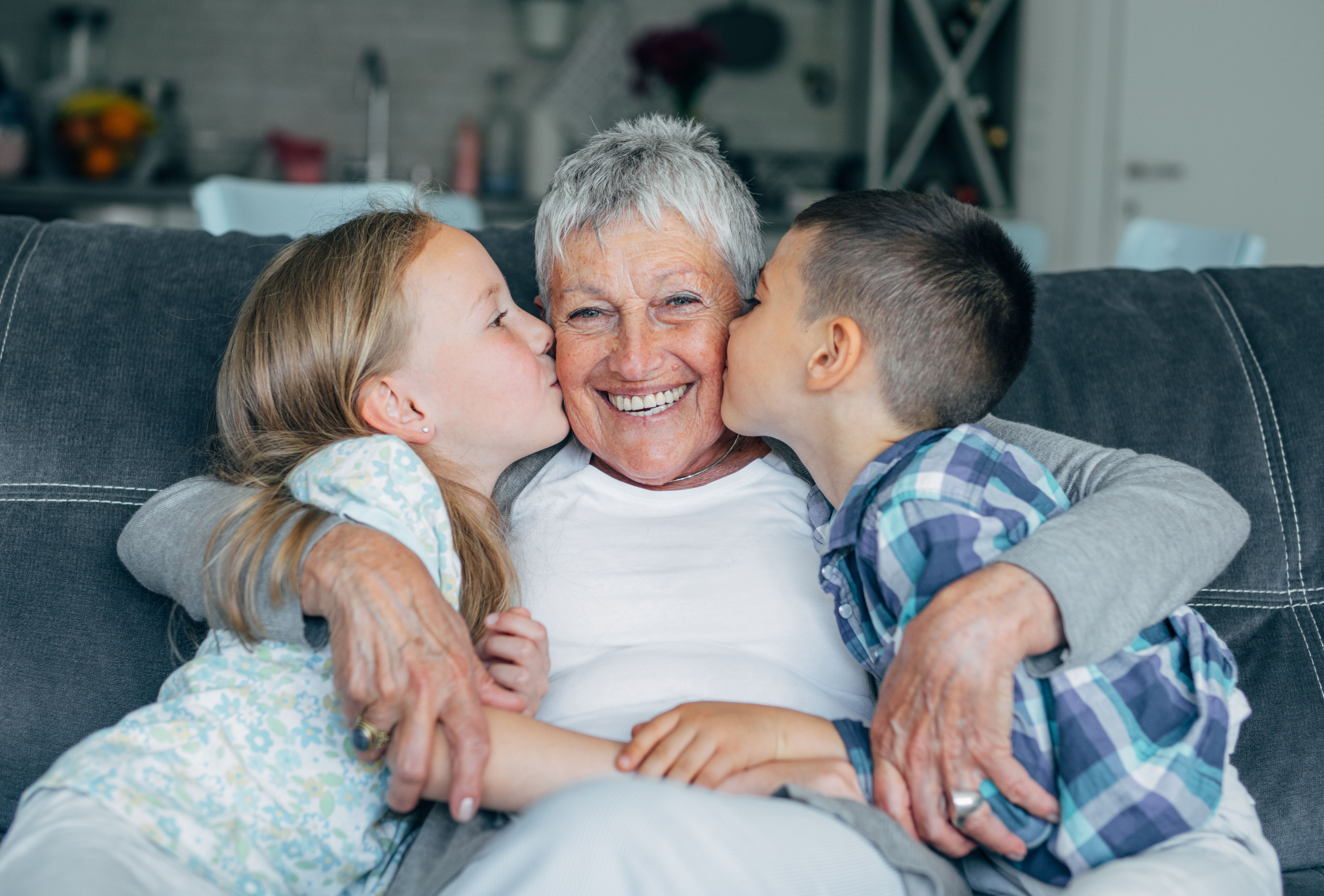 Petits-enfants embrassant leur grand-mère sur la joue | Source : Getty Images