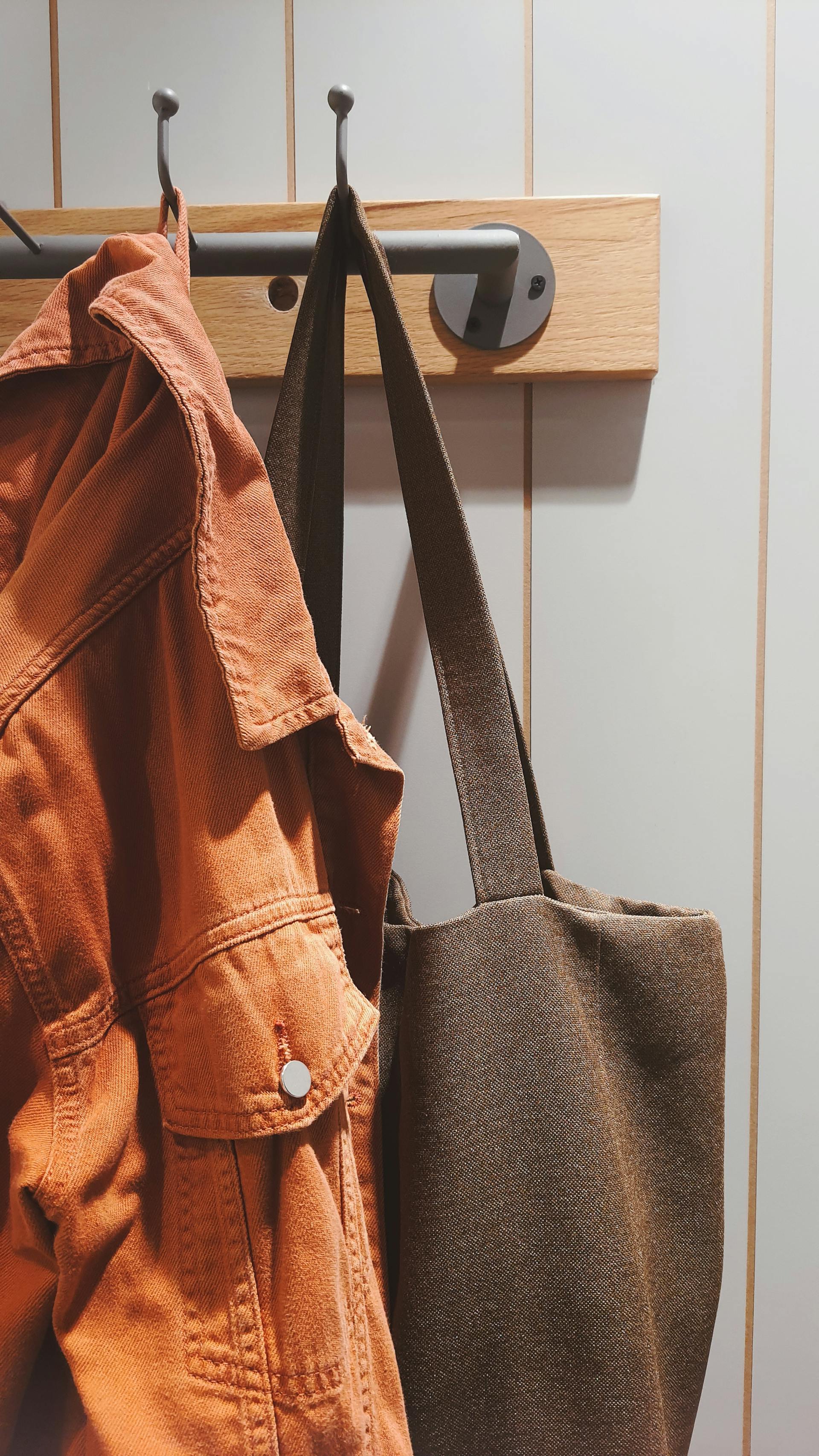 Un manteau et un sac suspendus à une étagère | Source : Pexels