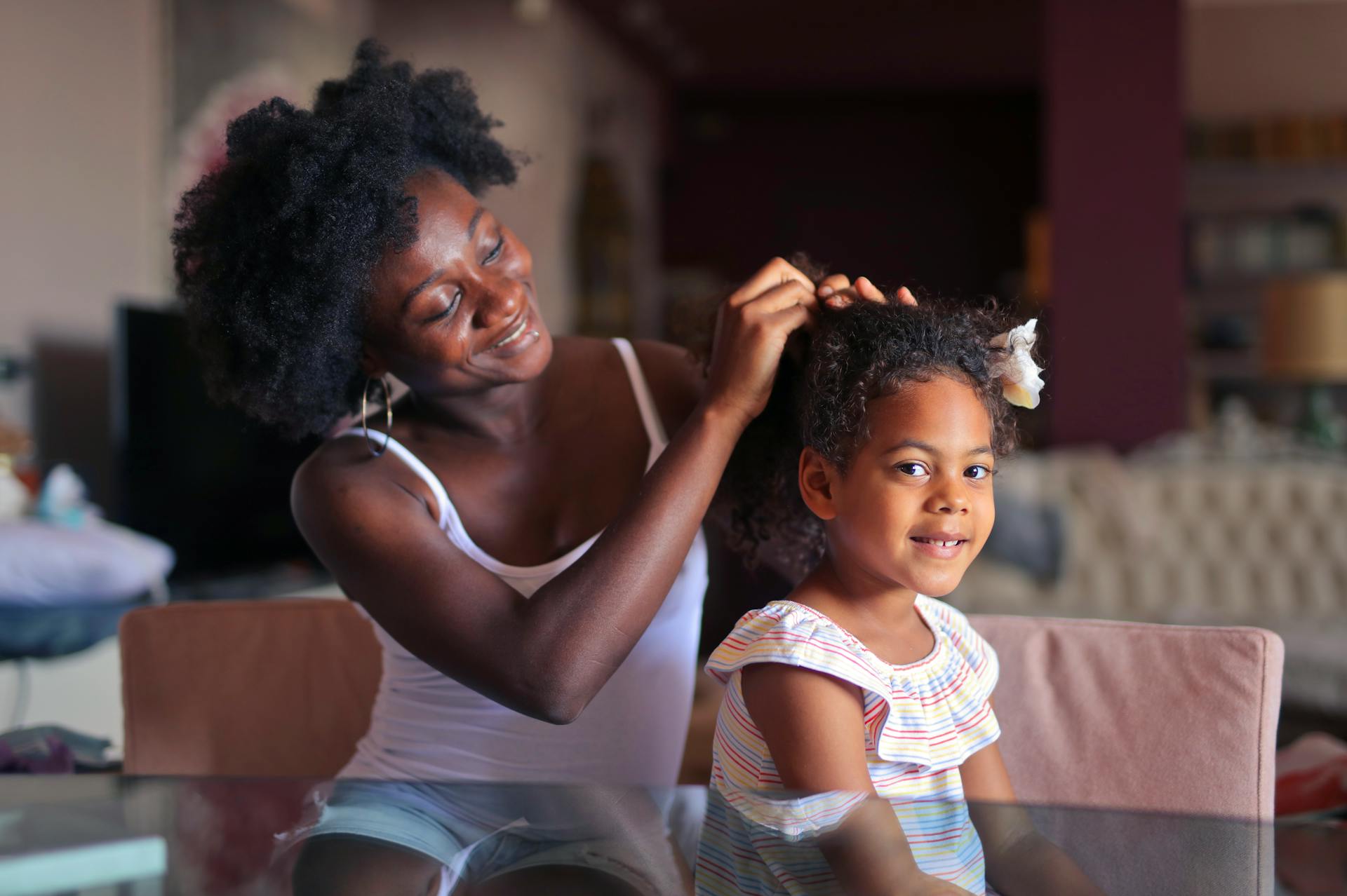 Une femme arrange les cheveux de sa fille | Source : Pexels