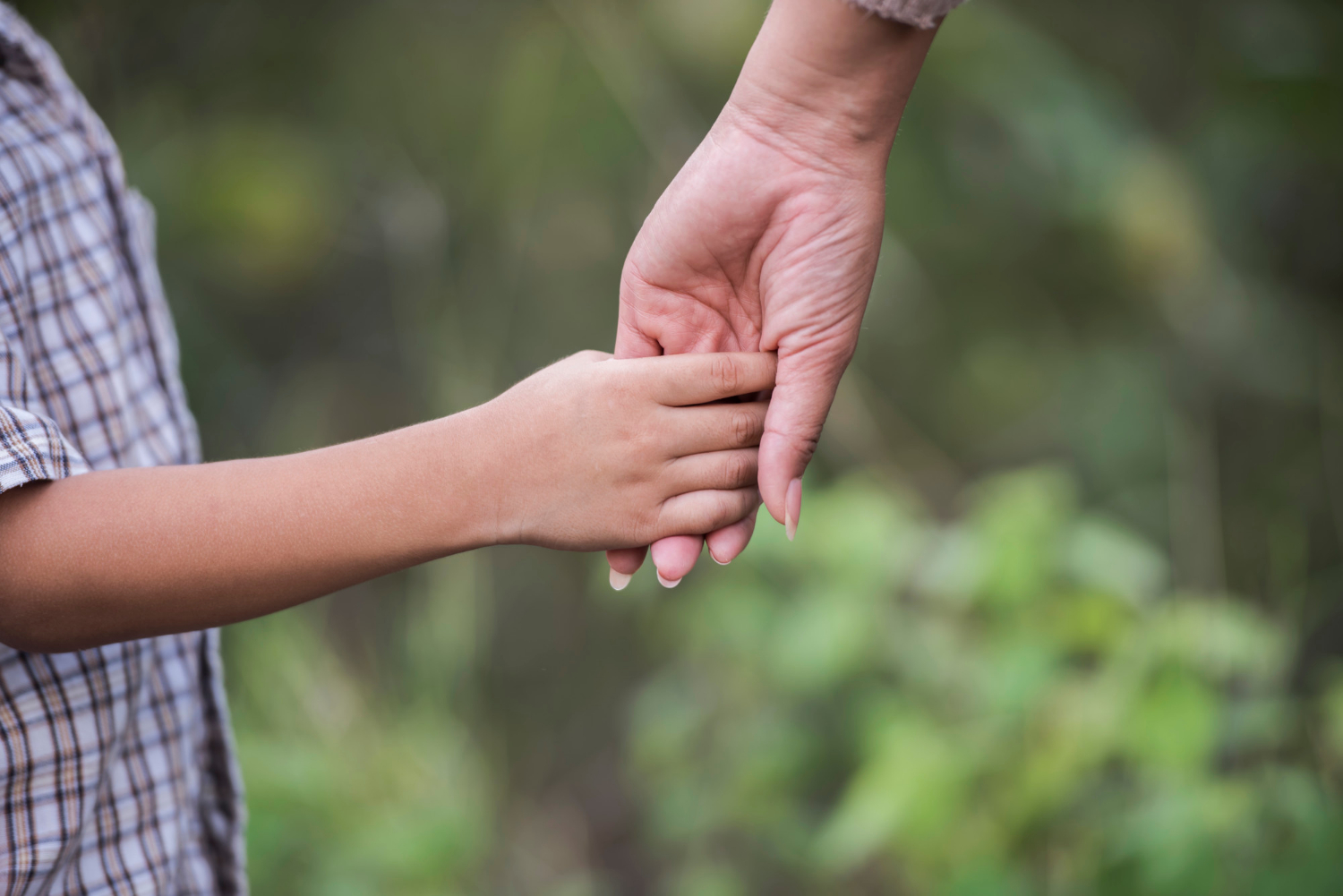 Gros plan sur une mère tenant la main de son fils | Source : Freepik