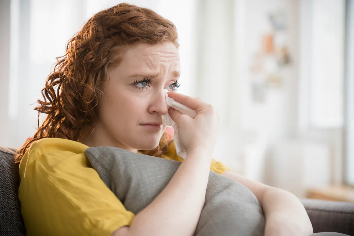 Une femme en larmes serrant un oreiller | Source : Getty Images
