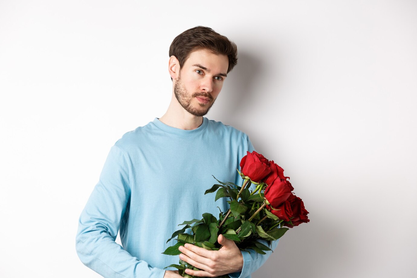 Un homme tenant un bouquet de roses | Source : FreePik