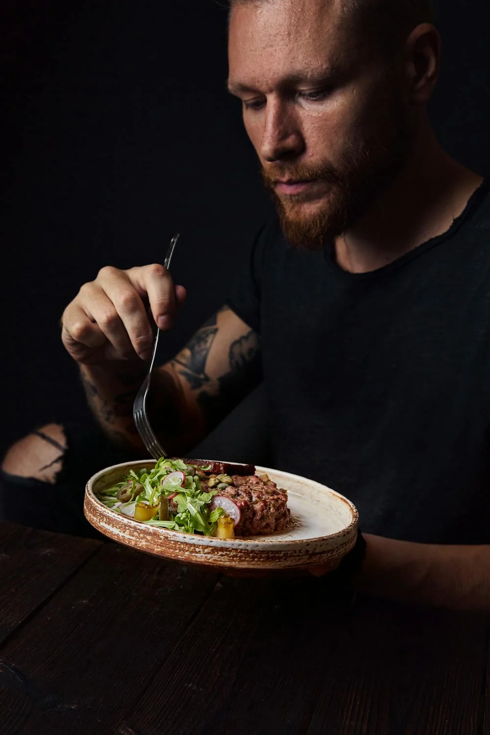 Un homme mangeant de la viande avec des légumes | Source : Pexels