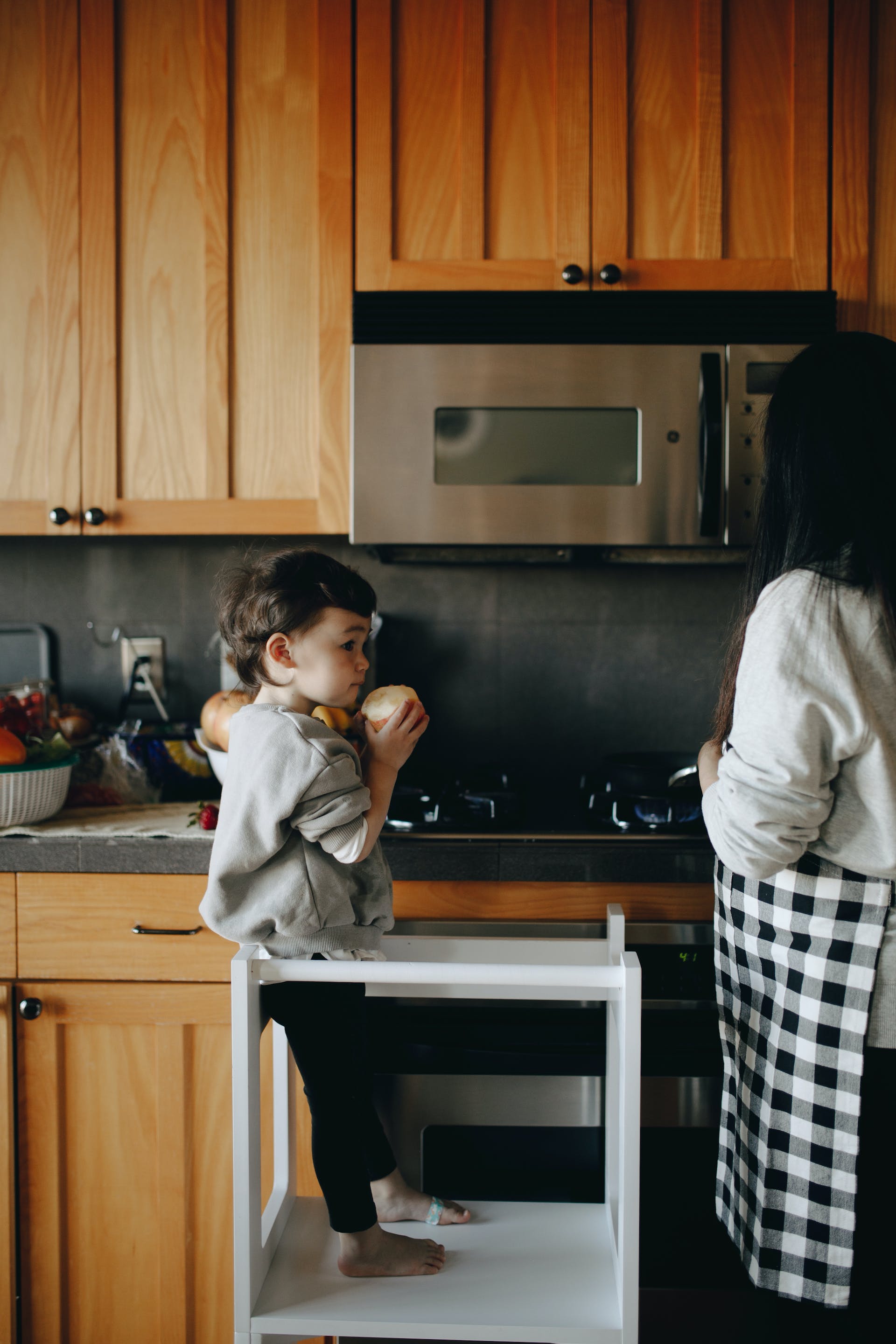 Un petit garçon debout à côté de sa maman dans la cuisine | Source : Pexels