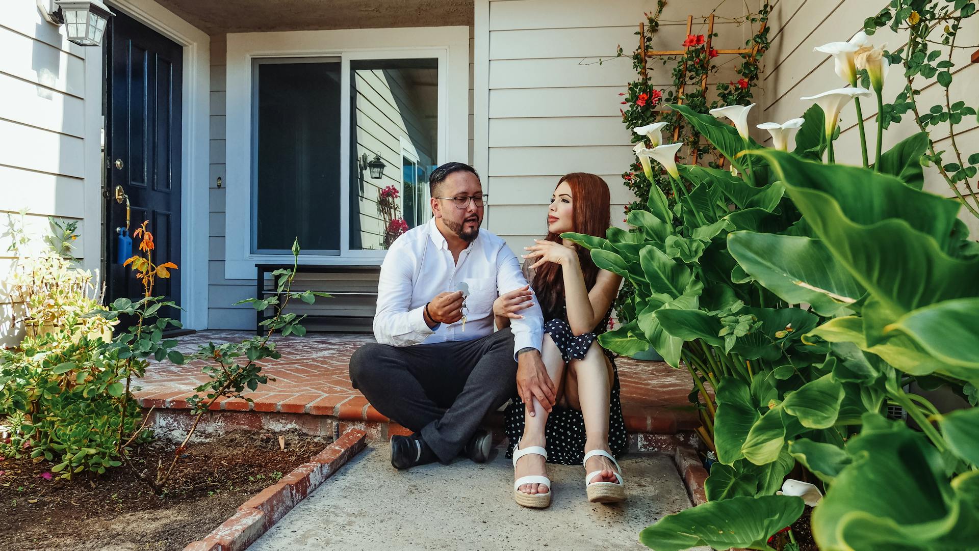 Un couple assis devant sa maison | Source : Pexels