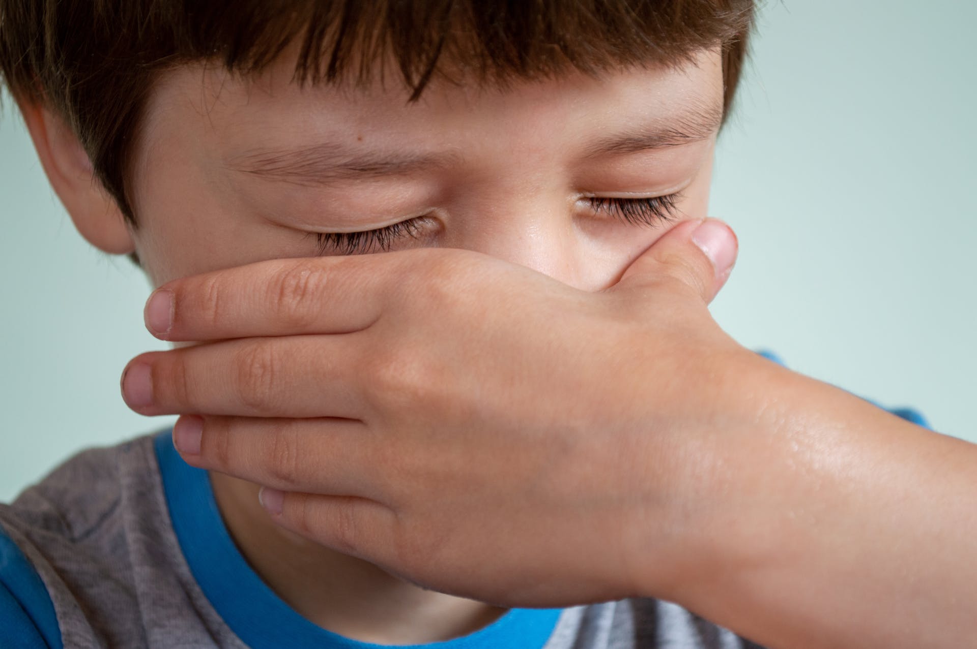 Un enfant se couvrant le nez avec sa main | Source : Pexels