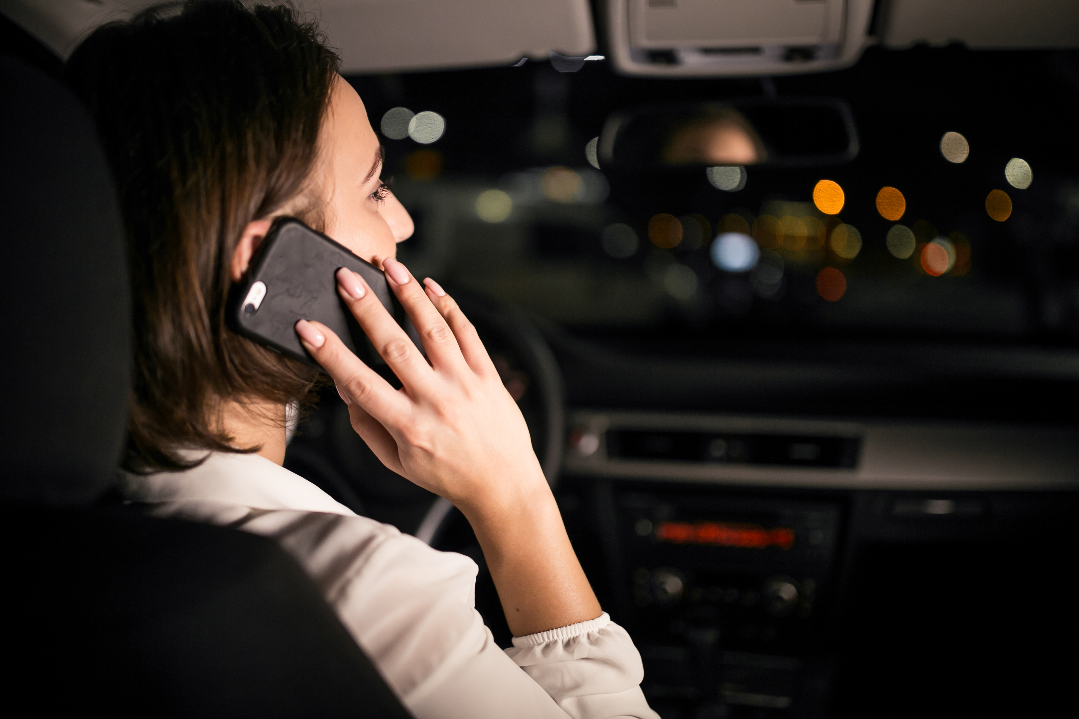 Une femme assise dans sa voiture et parlant au téléphone | Source : Freepik