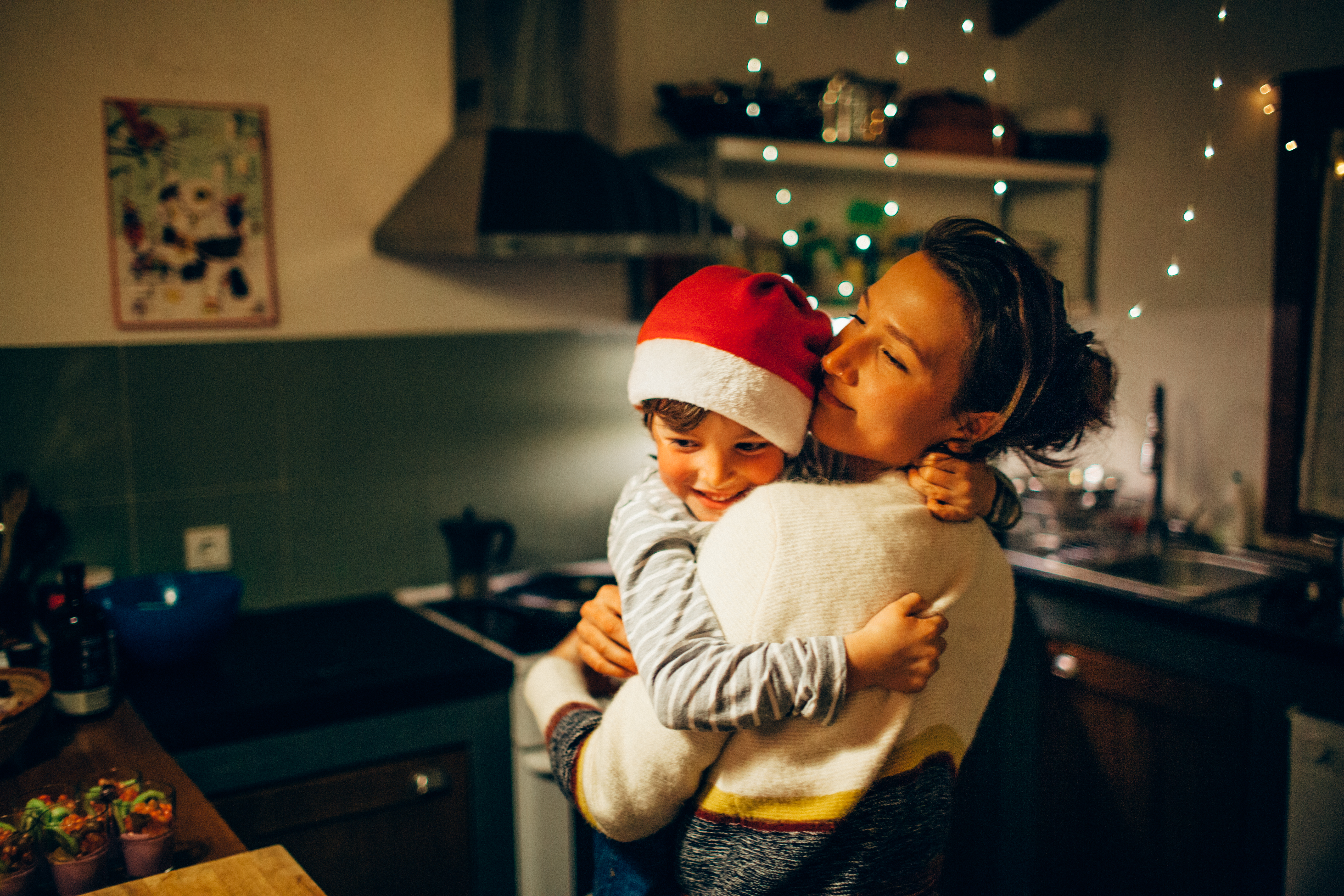 Mère et fils se serrant dans la cuisine à Noël | Source : Getty Images