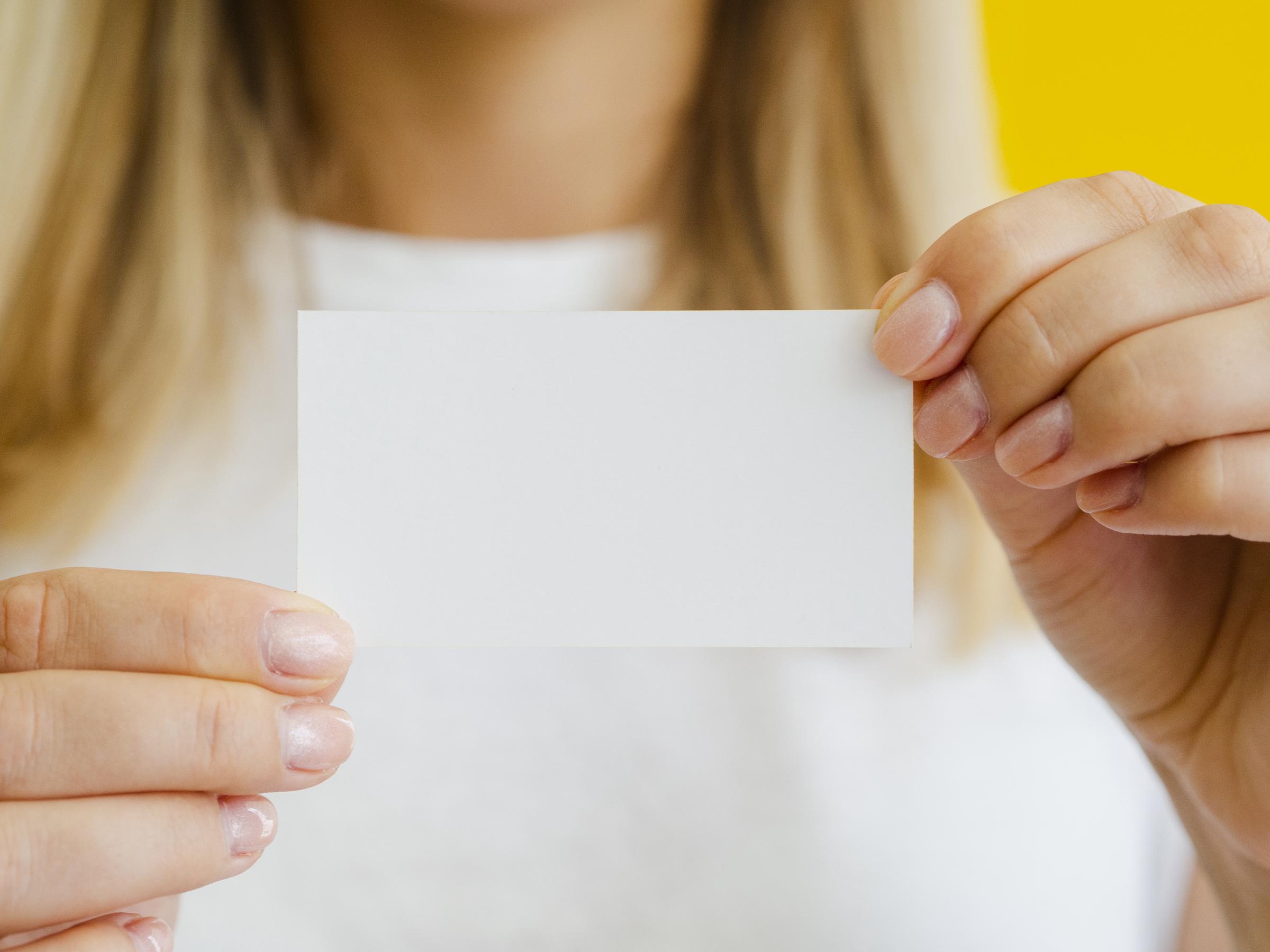 Une femme tenant une carte de visite | Source : Freepik