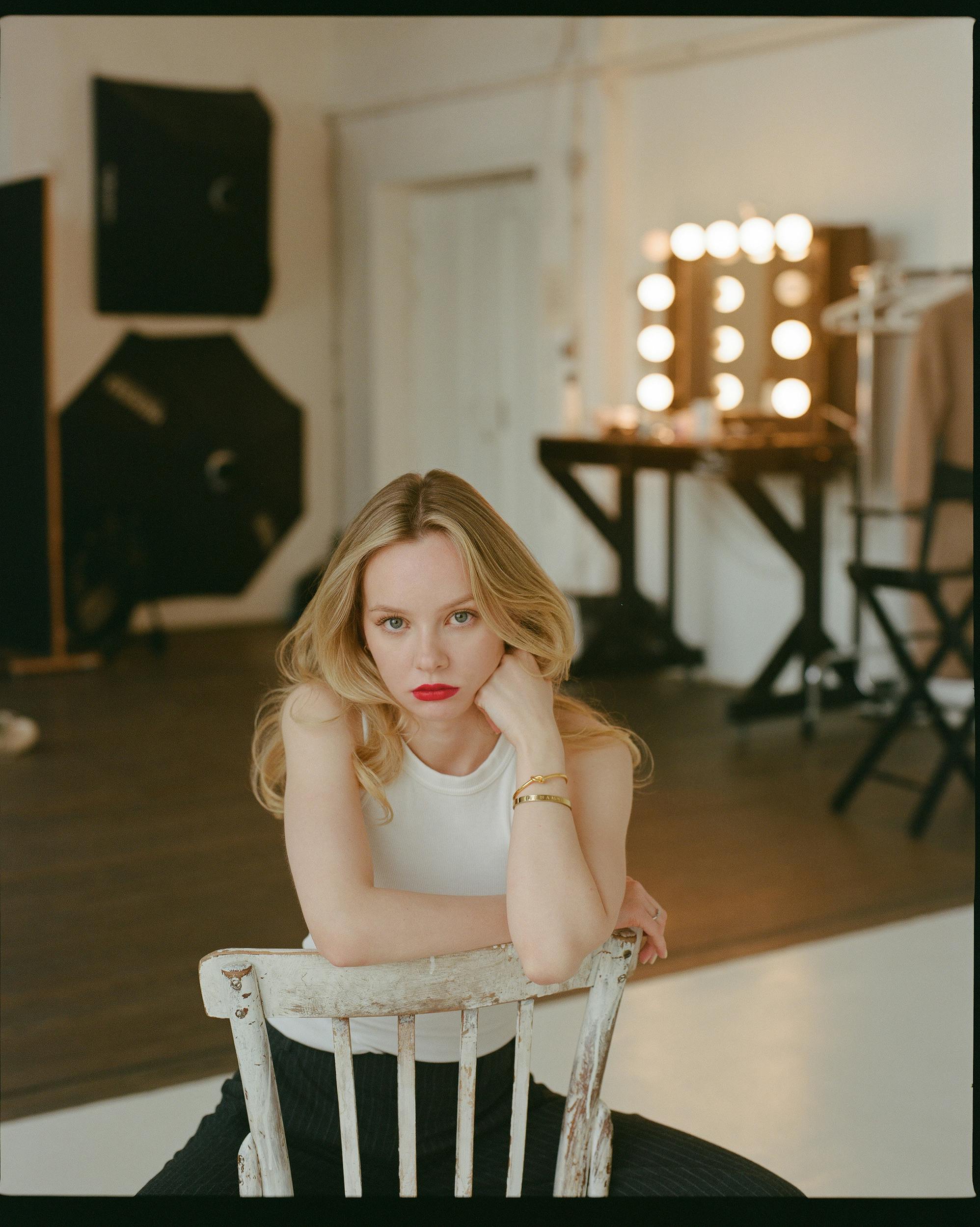 A woman sitting on a chair and taking a photo | Source: Pexels