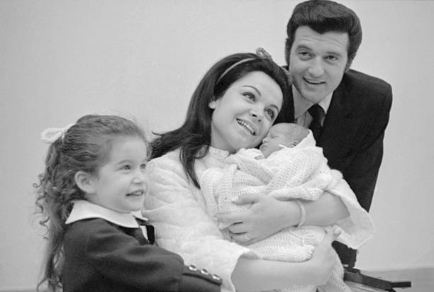 Annette Funicello câline son fils nouveau-né, Jack Jr, à l'hôpital St. Joseph, avec son mari, Jack Gilardi, et leur fille, Gina, le 13 février 1970. | Source : Getty Images