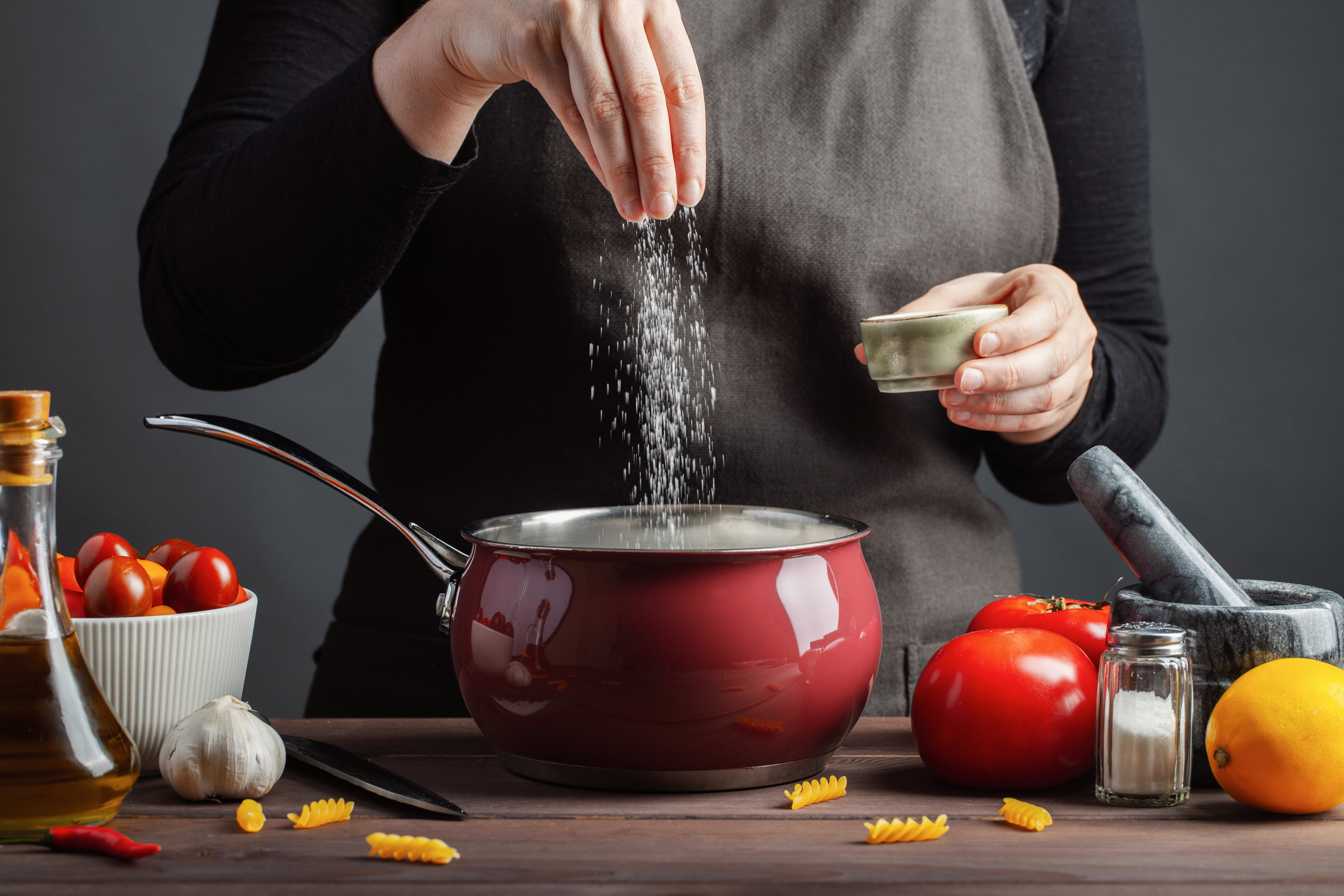 Une personne versant du sel dans un pot | Source : Shutterstock