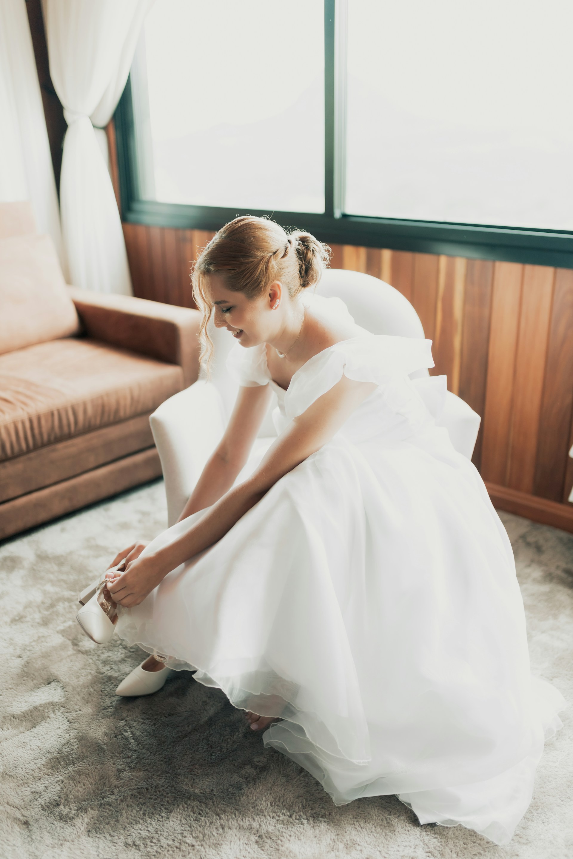 Une mariée qui rit en arrangeant sa chaussure | Source : Unsplash