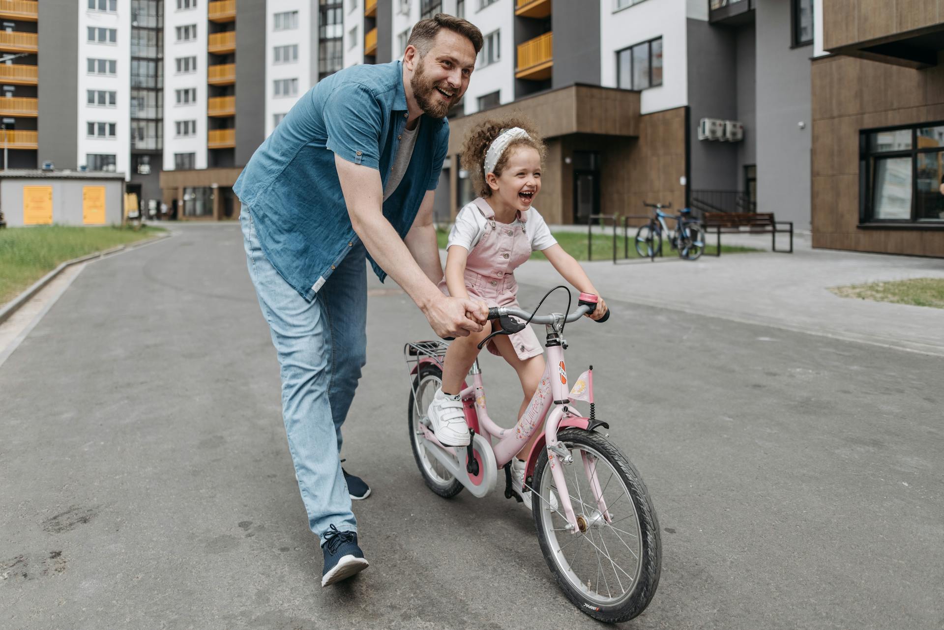 Un homme aidant sa fille à faire du vélo | Source : Pexels