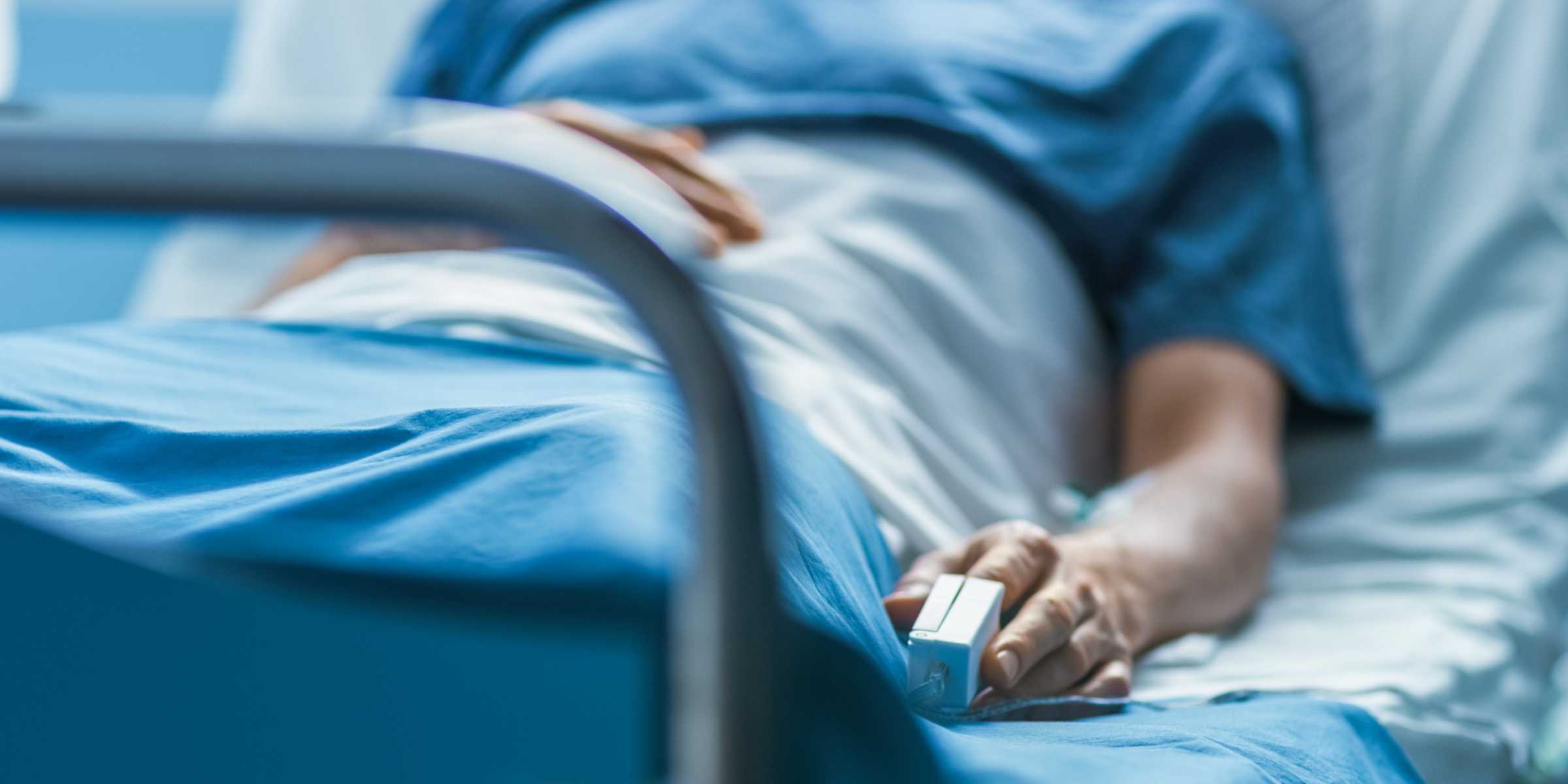 Un patient hospitalisé est allongé dans son lit et porte un oxymètre de pouls sur son doigt | Source : Getty Images