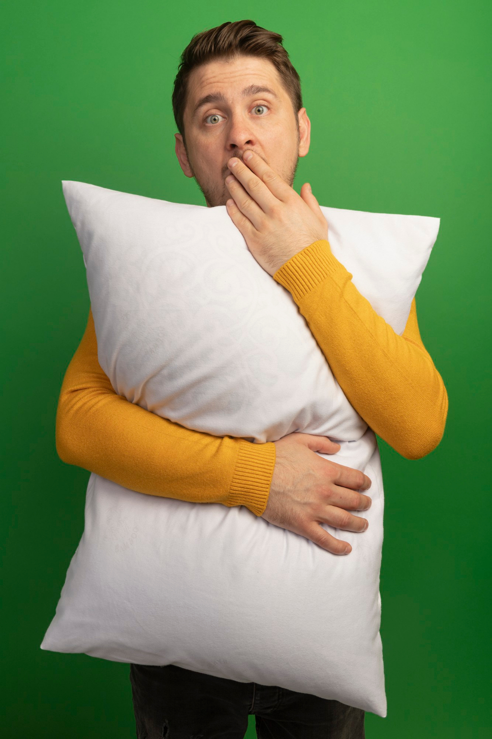 Un homme stupéfait tenant un oreiller | Source : Freepik