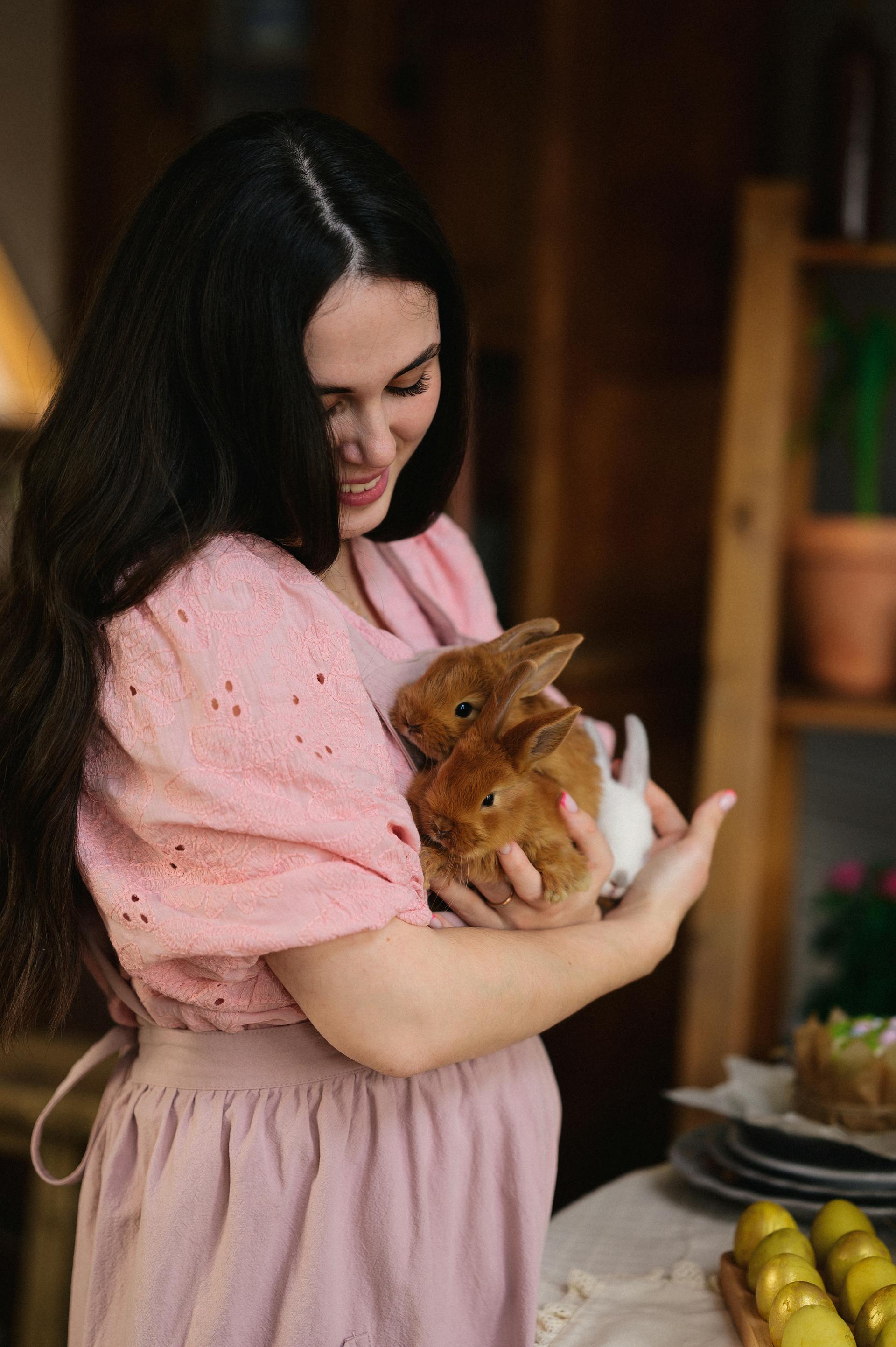 Une femme souriante tenant des lapins | Source : Pexels