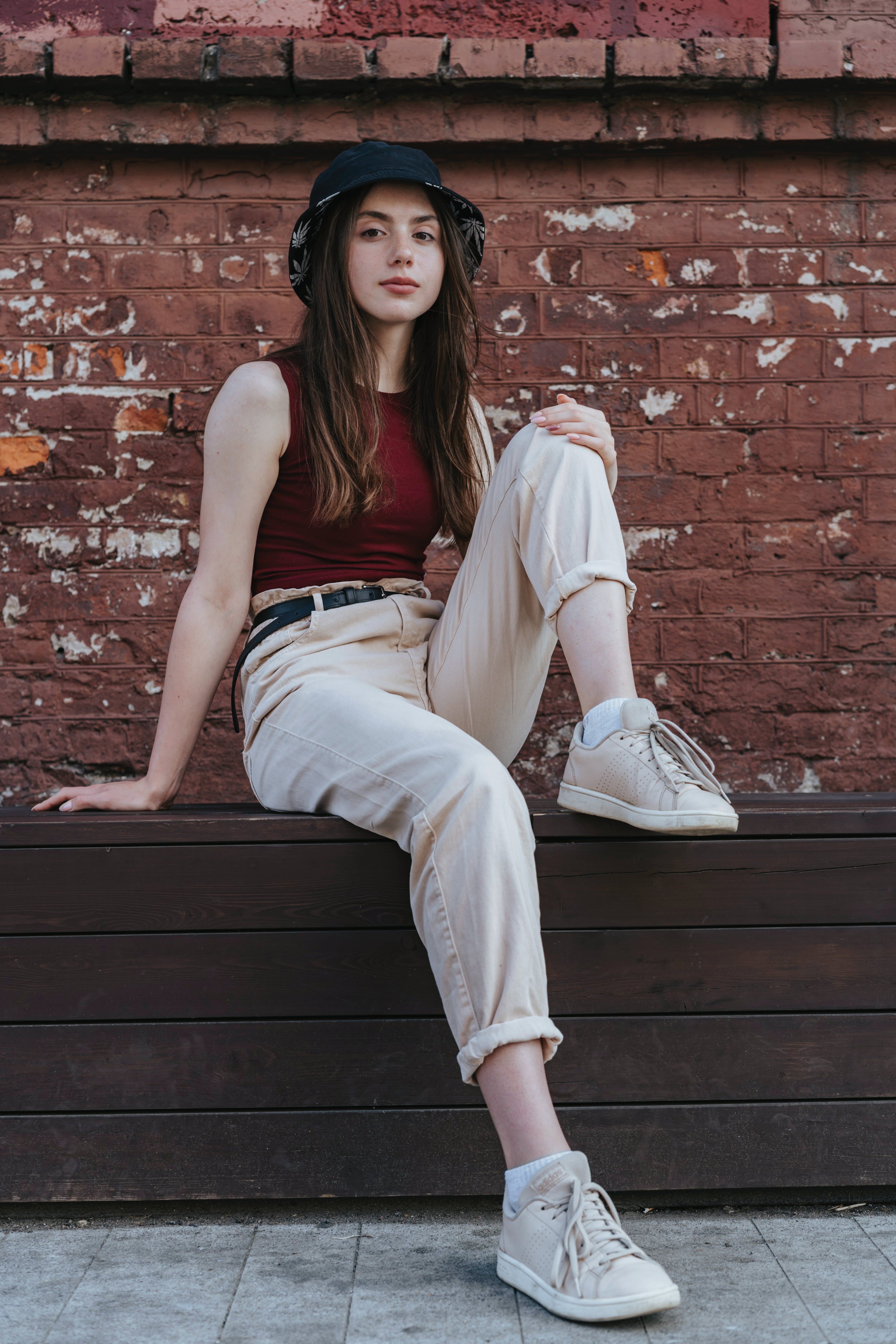Une jeune fille assise près d'un mur | Source : Pexels