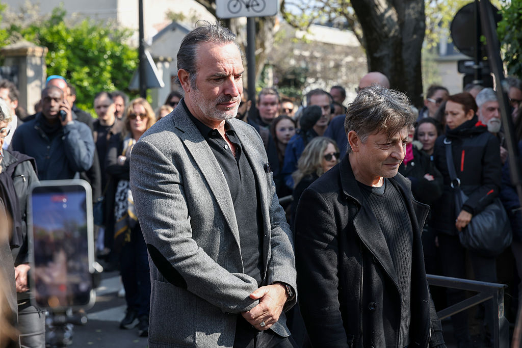 Jean Dujardin et Éric Massot marchent derrière le corbillard lors des funérailles de Bruno Salomone, le 23 mars 2026 à Joinville-le-Pont, en France I Source : Getty Images