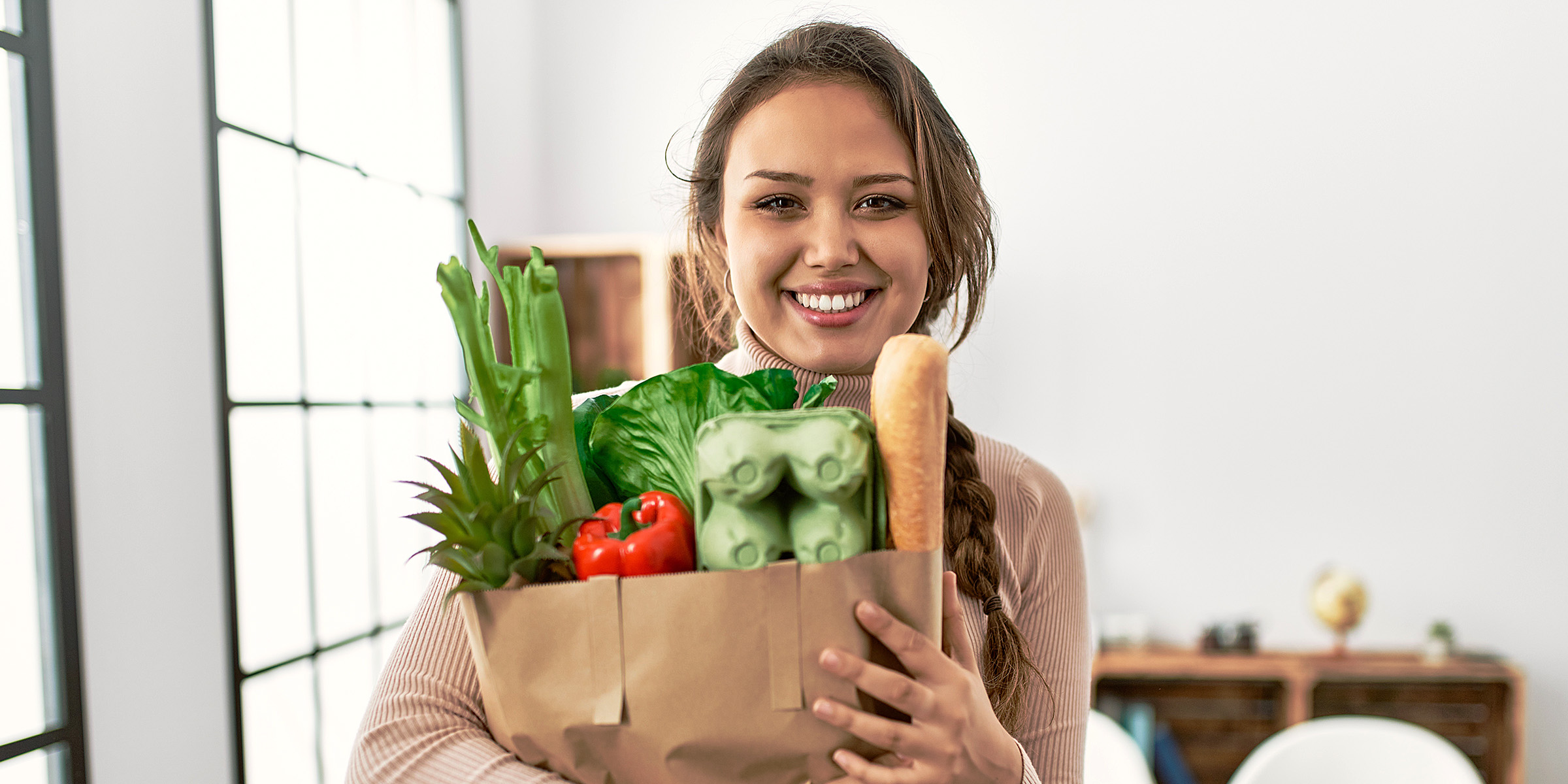 Une femme tenant un sac de provisions | Source : Shutterstock