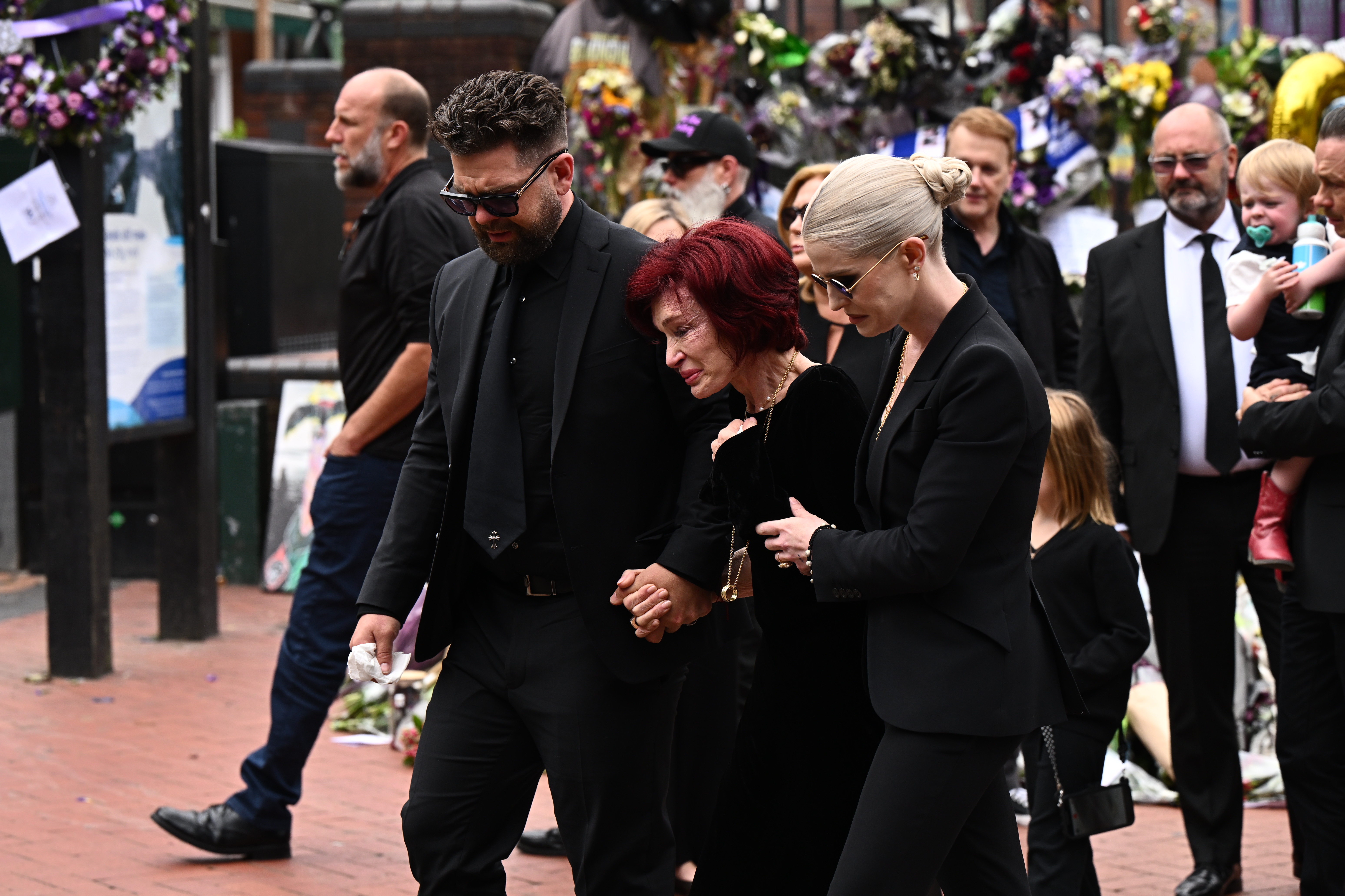 La famille d'Ozzy devant les hommages des fans de feu Ozzy pendant son cortège funèbre à Birmingham le 30 juillet 2025 | Source : Getty Images