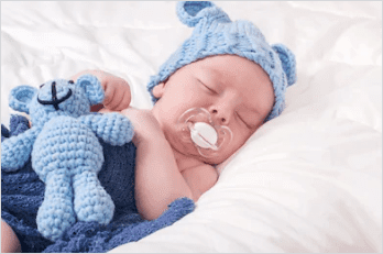 Un bébé endormi avec sa sucette. | Shutterstock