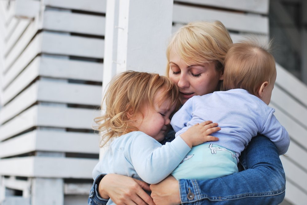 Une femme triste avec deux enfants. | Photo : Shutterstock