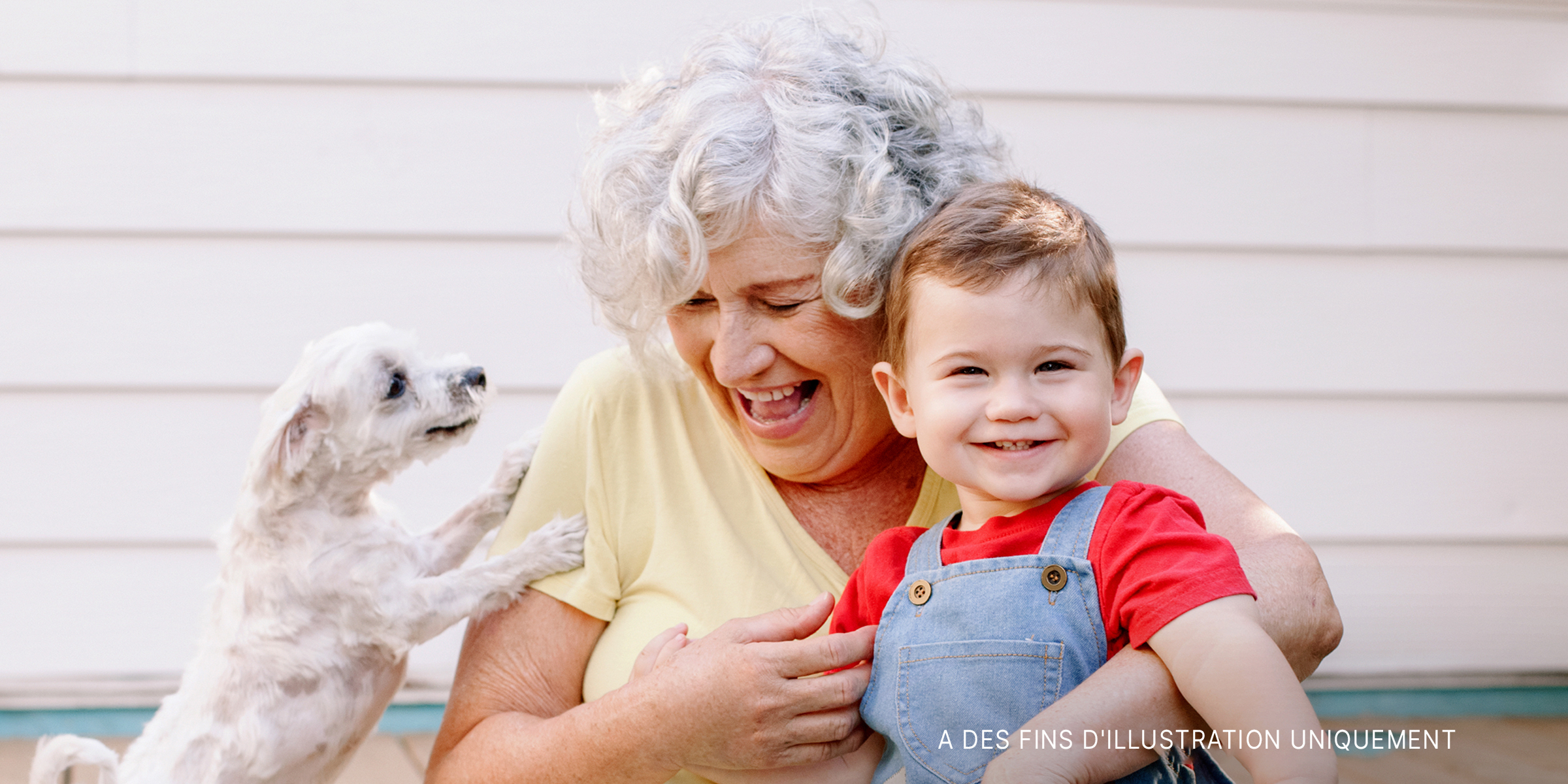 Une grand-mère et son petit-enfant avec un chiot | Source : Shutterstock
