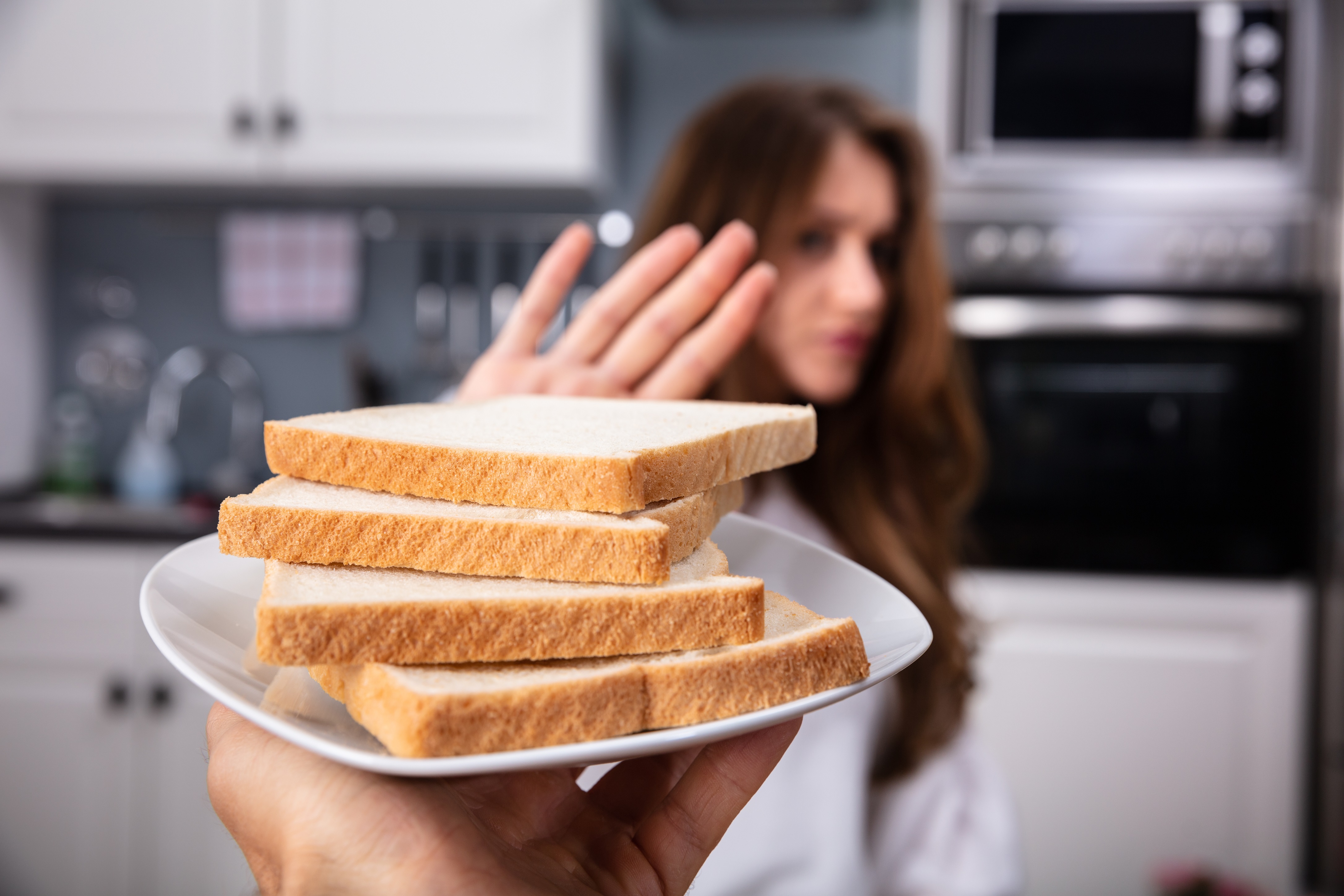 Une femme refusant une assiette de pain blanc | Source : Shutterstock