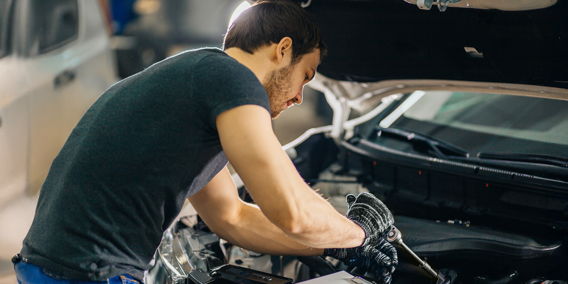 Un homme réparant une voiture | Source : Shutterstock