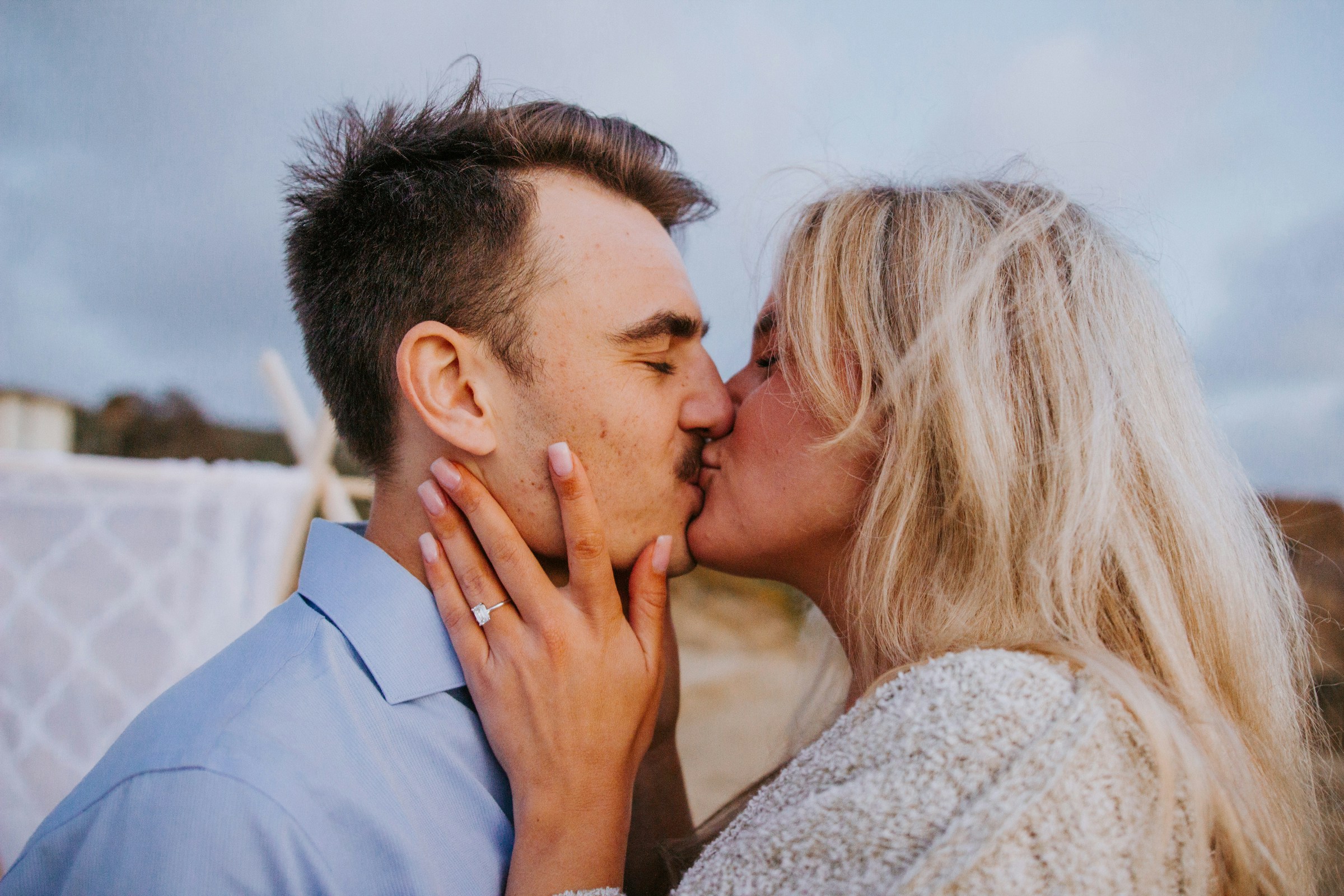 Un couple s'embrasse en montrant sa bague de fiançailles | Source : Unsplash