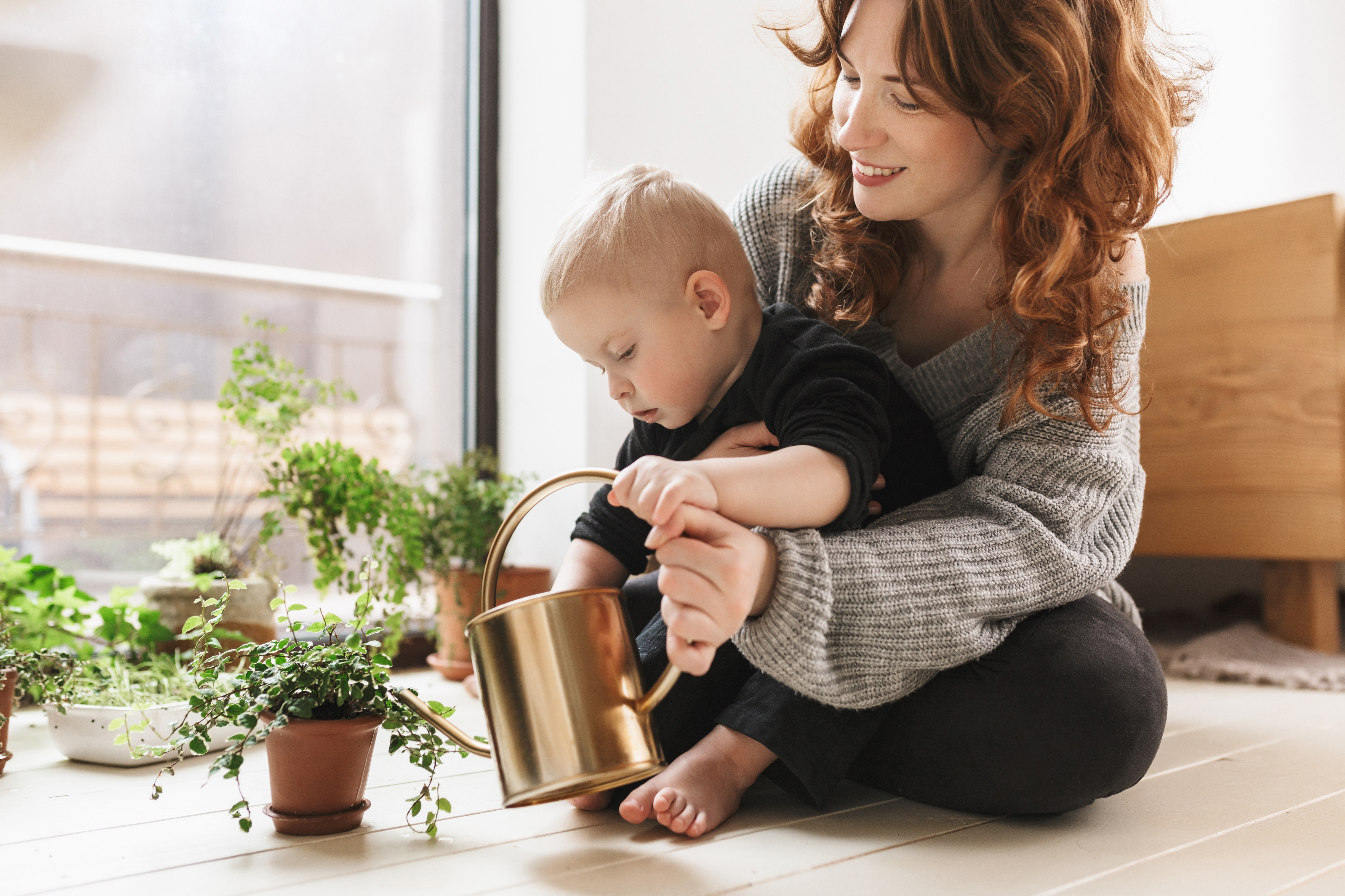 Une femme apprend à son bébé comment arroser les plantes | Source : Shutterstock