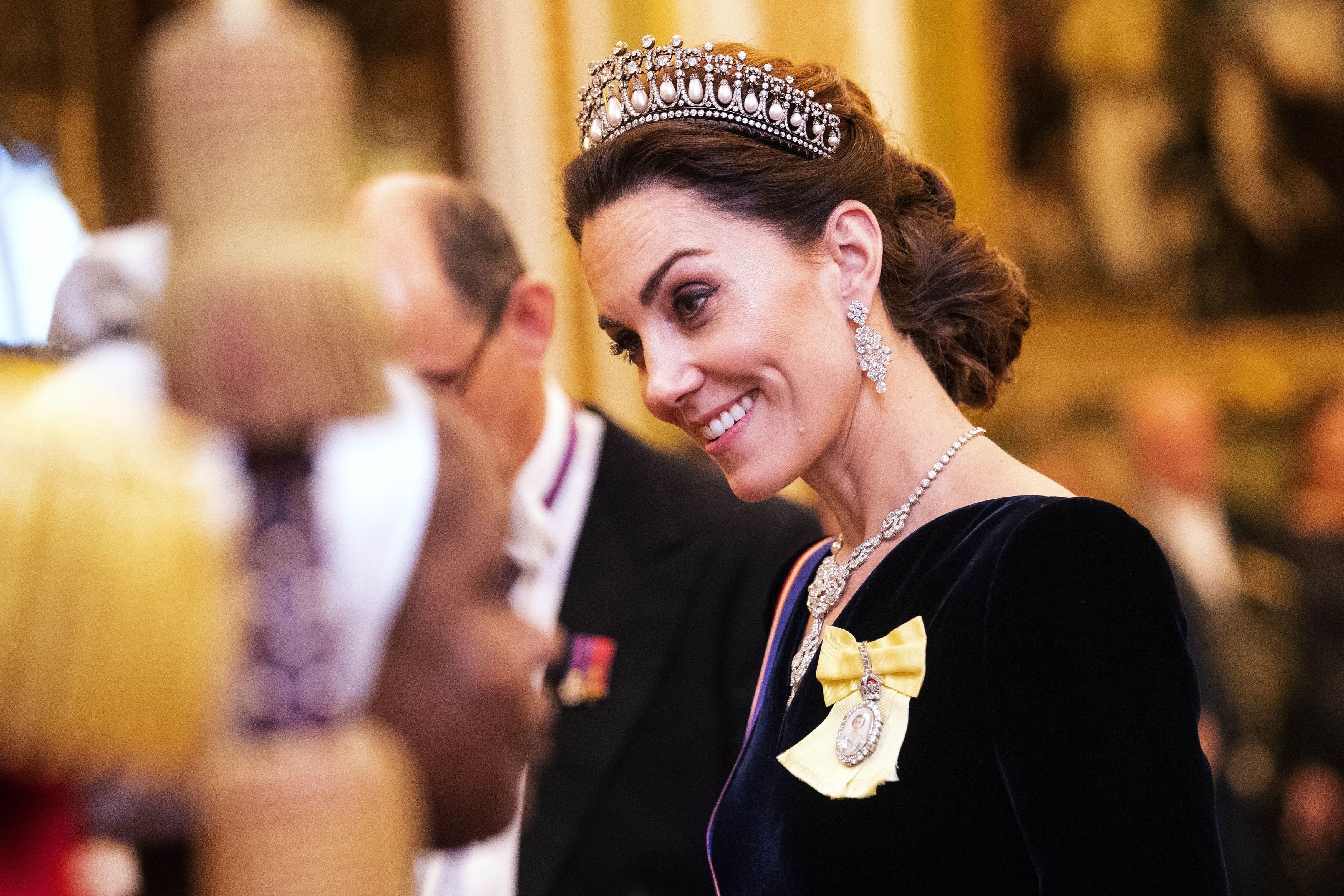 Kate Middleton s'entretient avec des invités lors d'une réception en soirée pour les membres du corps diplomatique à Buckingham Palace. | Source : Getty Images