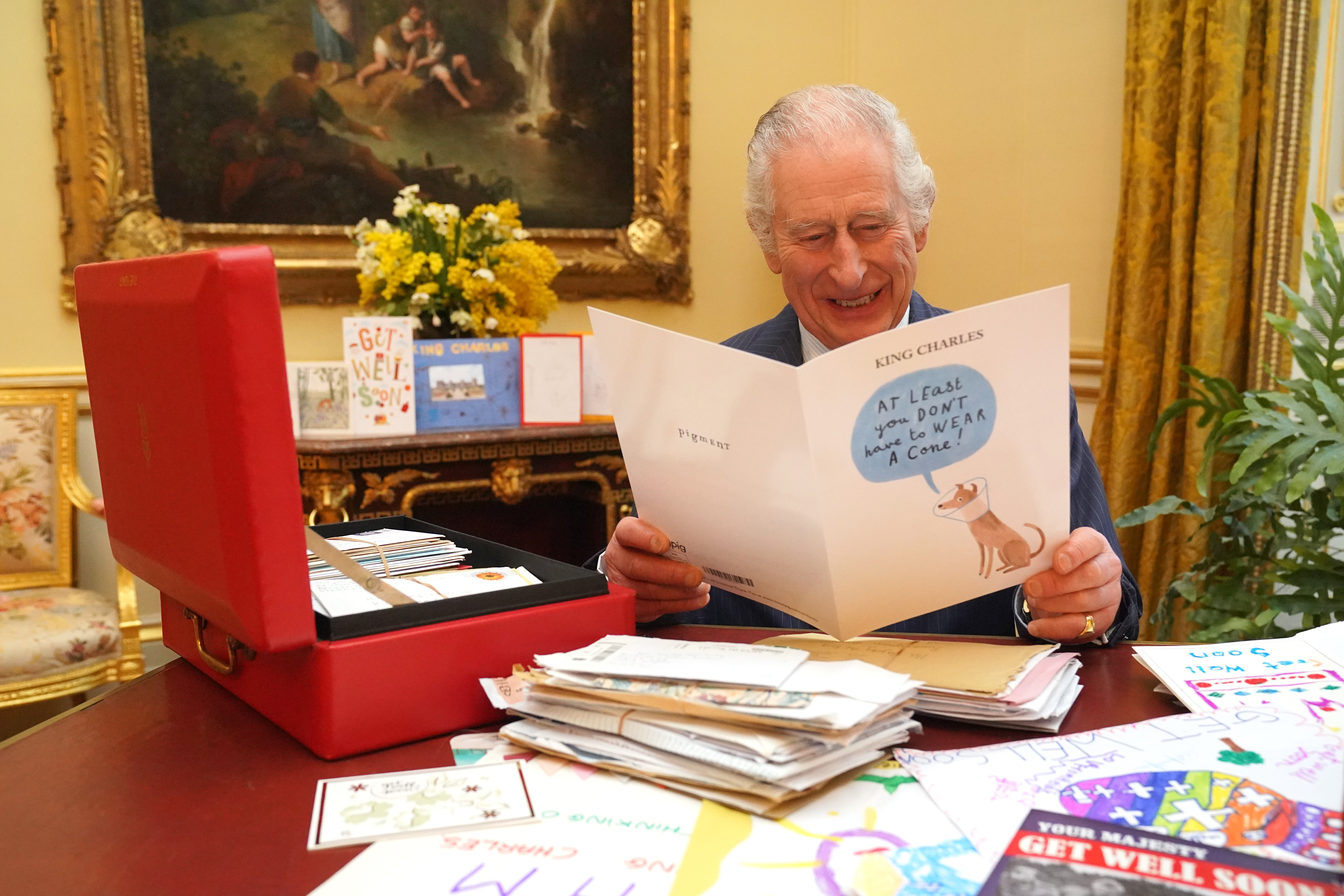 Le roi Charles lisant des cartes envoyées par des bienfaiteurs suite à son diagnostic de cancer, dans la salle du 18e siècle de la suite belge du palais de Buckingham, le 21 février 2024 à Londres, Angleterre | Source : Getty Images
