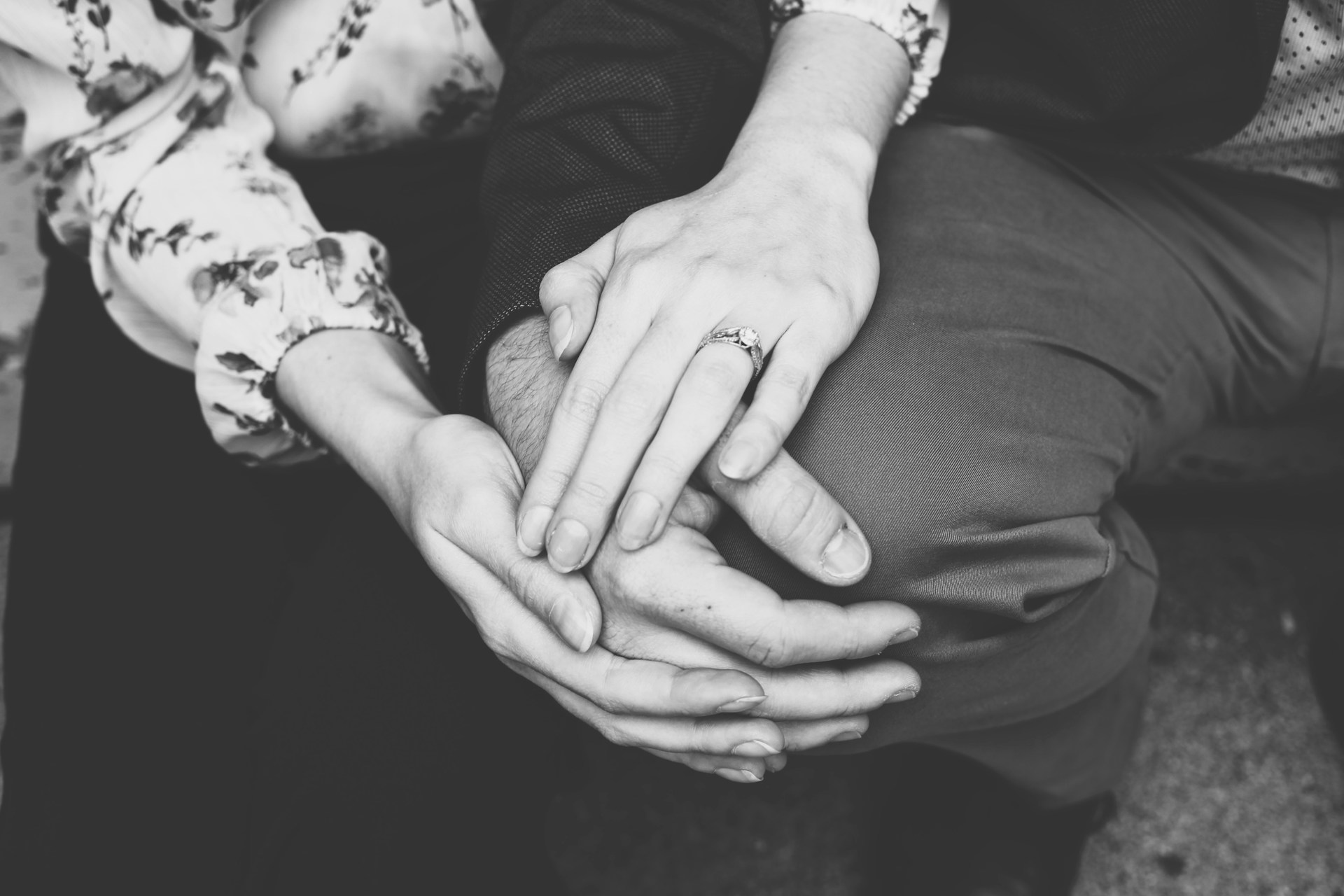 Photo en niveaux de gris d'un couple se tenant par la main | Source : Unsplash
