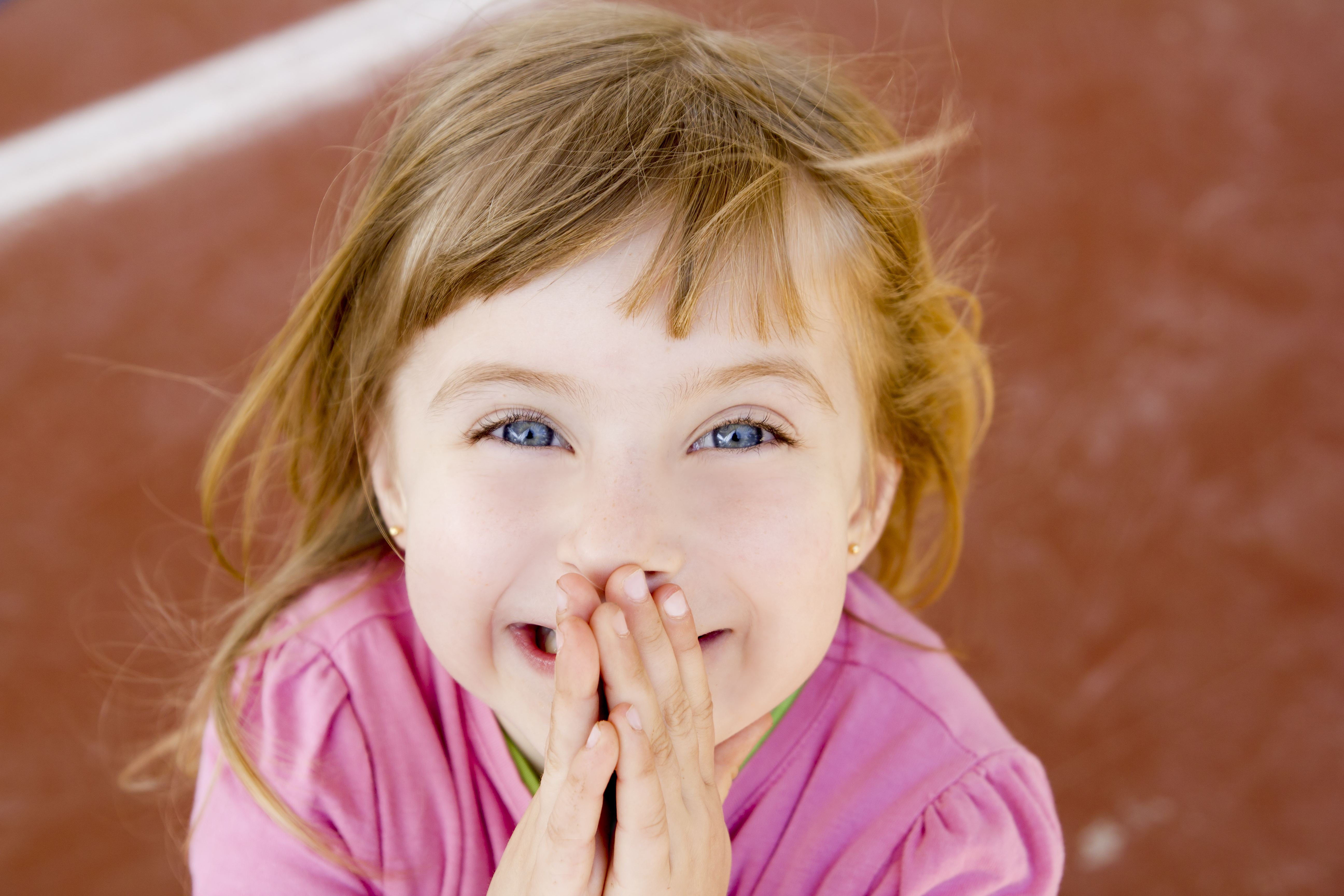 Blonde heureuse souriante petite fille excitée rire | Source : Getty Images
