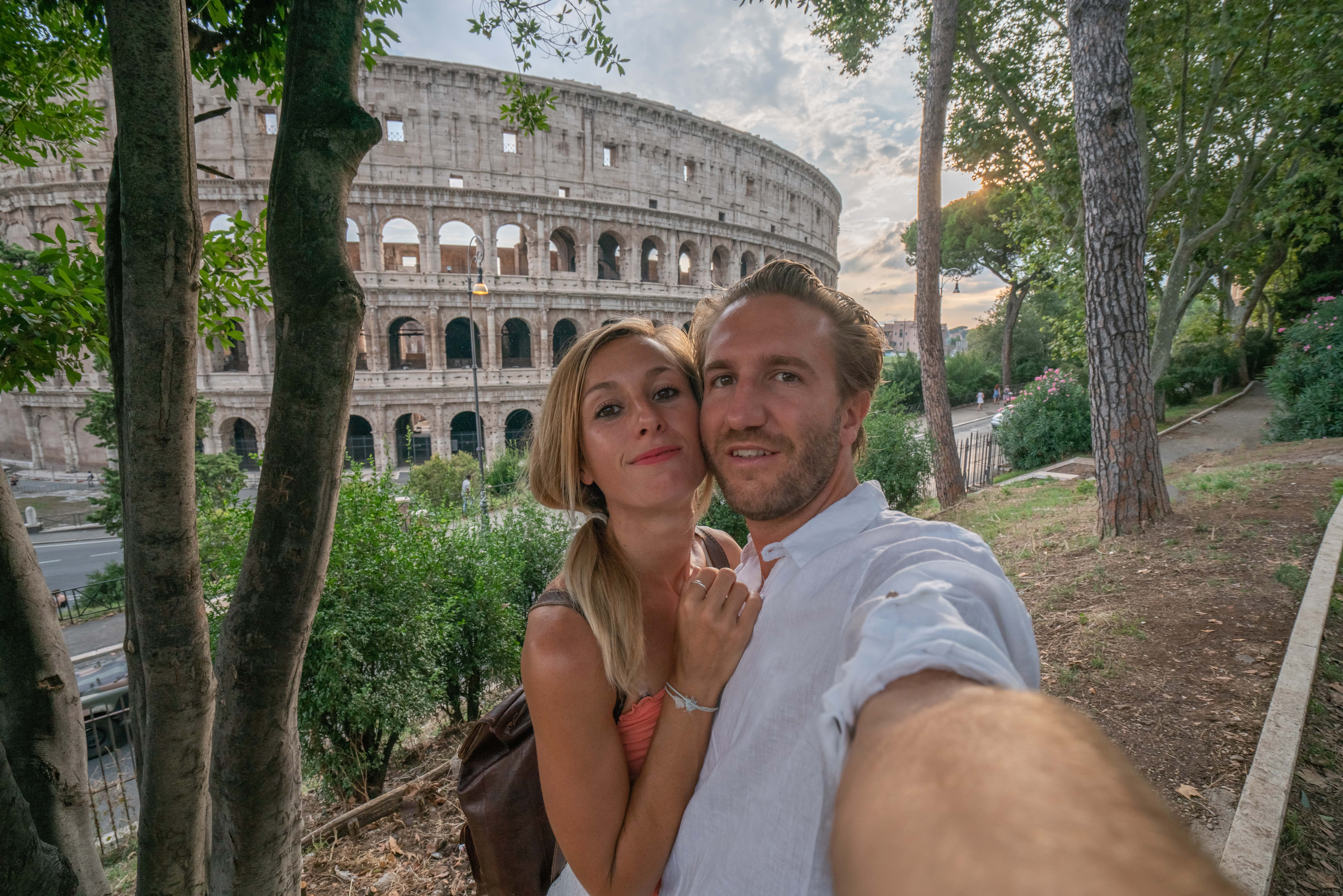 Un couple pose pour un selfie devant le Colisée à Rome | Source : Getty Images