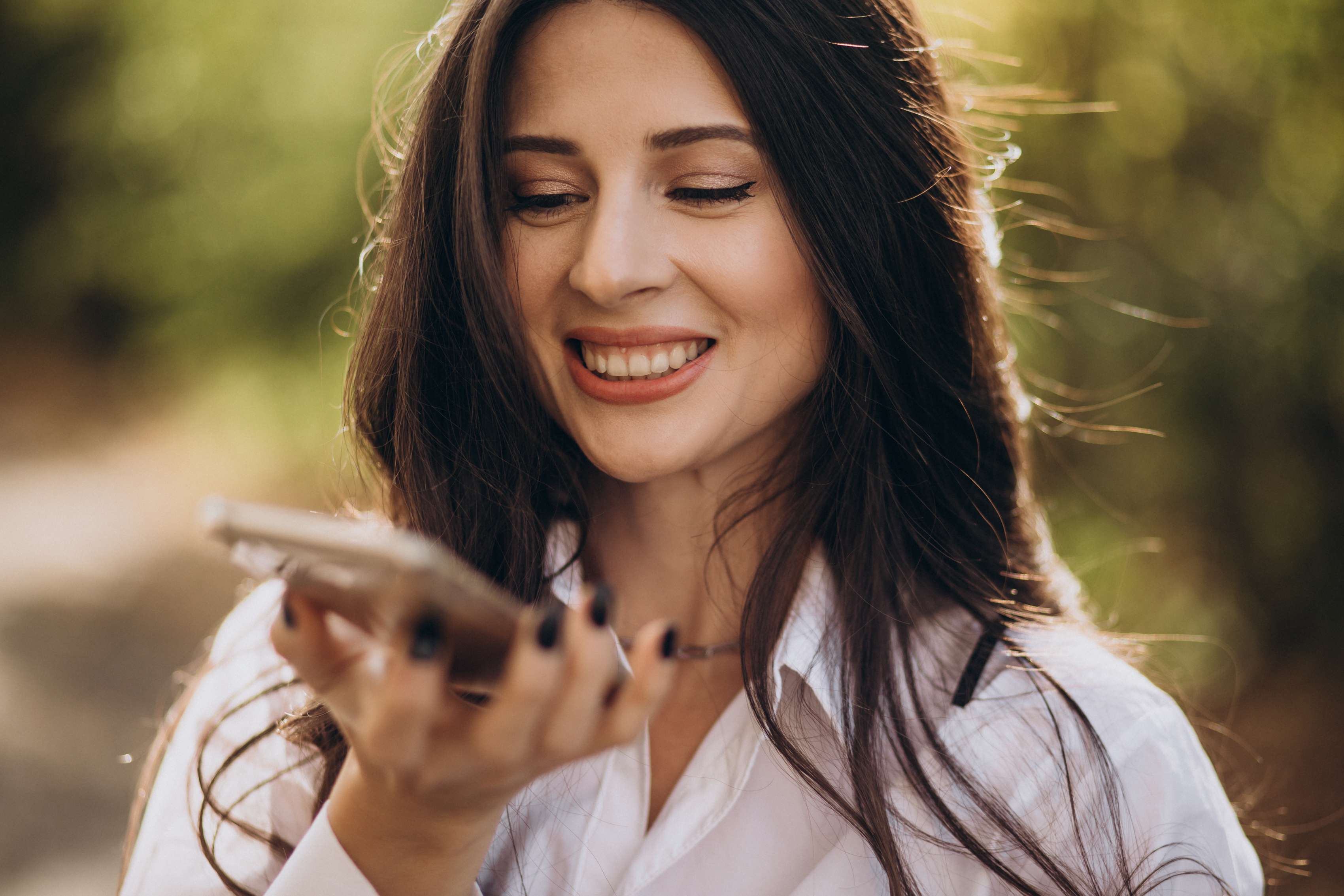 Une femme souriante qui parle au téléphone | Source : Freepik