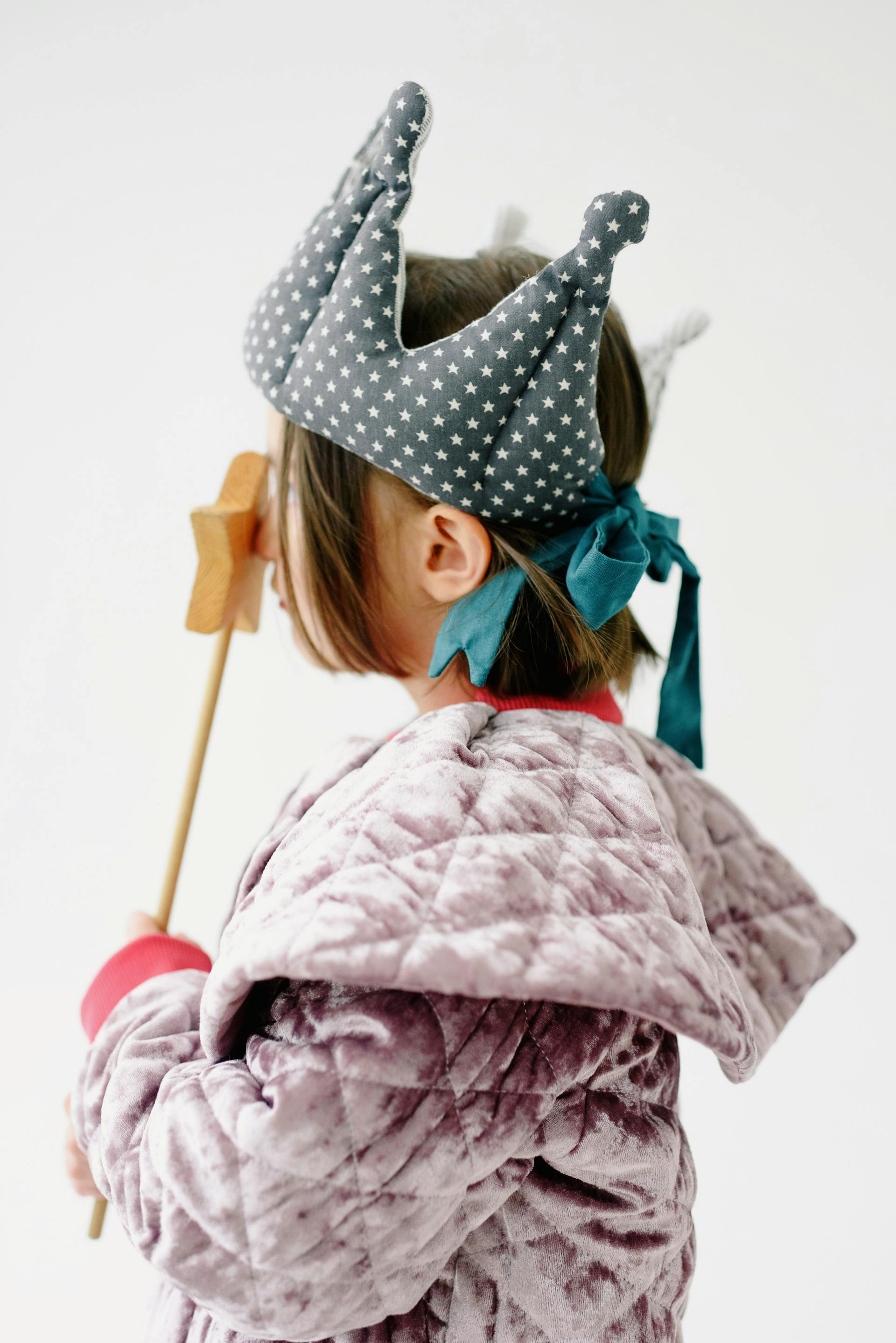 Une petite fille portant une couronne et tenant une baguette | Source : Pexels