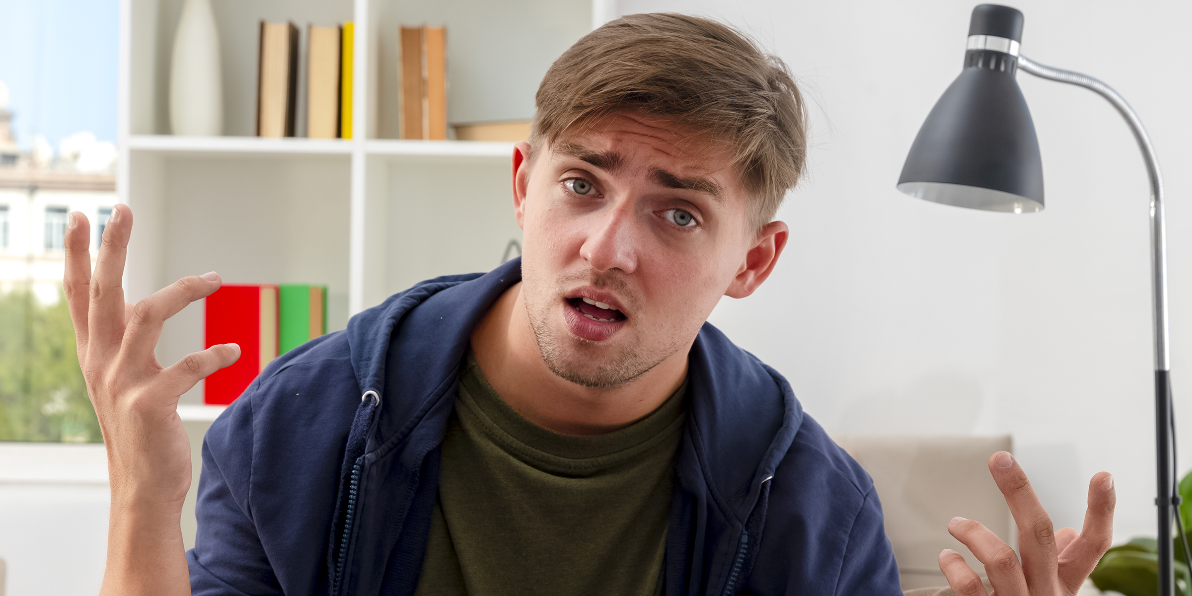 Un jeune homme confus et frustré assis à l'intérieur | Source : Freepik/stockking